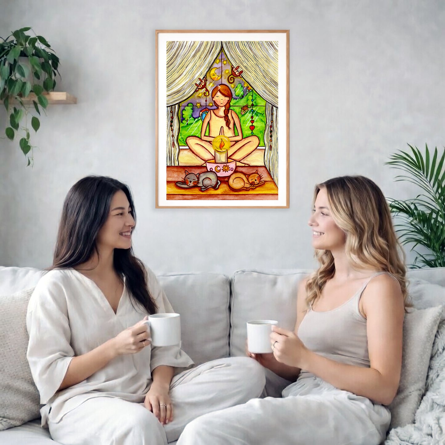 Candlelight trataka meditation design on mindfulness poster. The poster is framed and is in the center of the living room wall. Two female friends are having tea, grapes and cookies on a coffee table in front of the poster. On the left there is a green potted plant and to the right there is a hanging lamp.