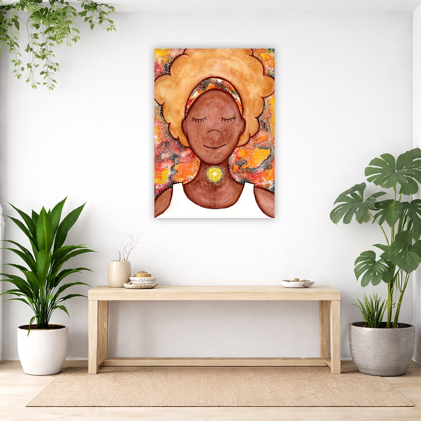 Woman's throat chakra energy glowing canvas. This is a print of the original hand-painted watercolor by Brazilian artist Thaís Suizo from the LET'S MEDITATE SERIES of mediation guides. The poster is in the center of the living room wall. Below the poster is a bench. On the bench is burning incense and a couple of bowls. There is a green potted plant on both the left and right side of the bench. There is a hanging plant on the left.