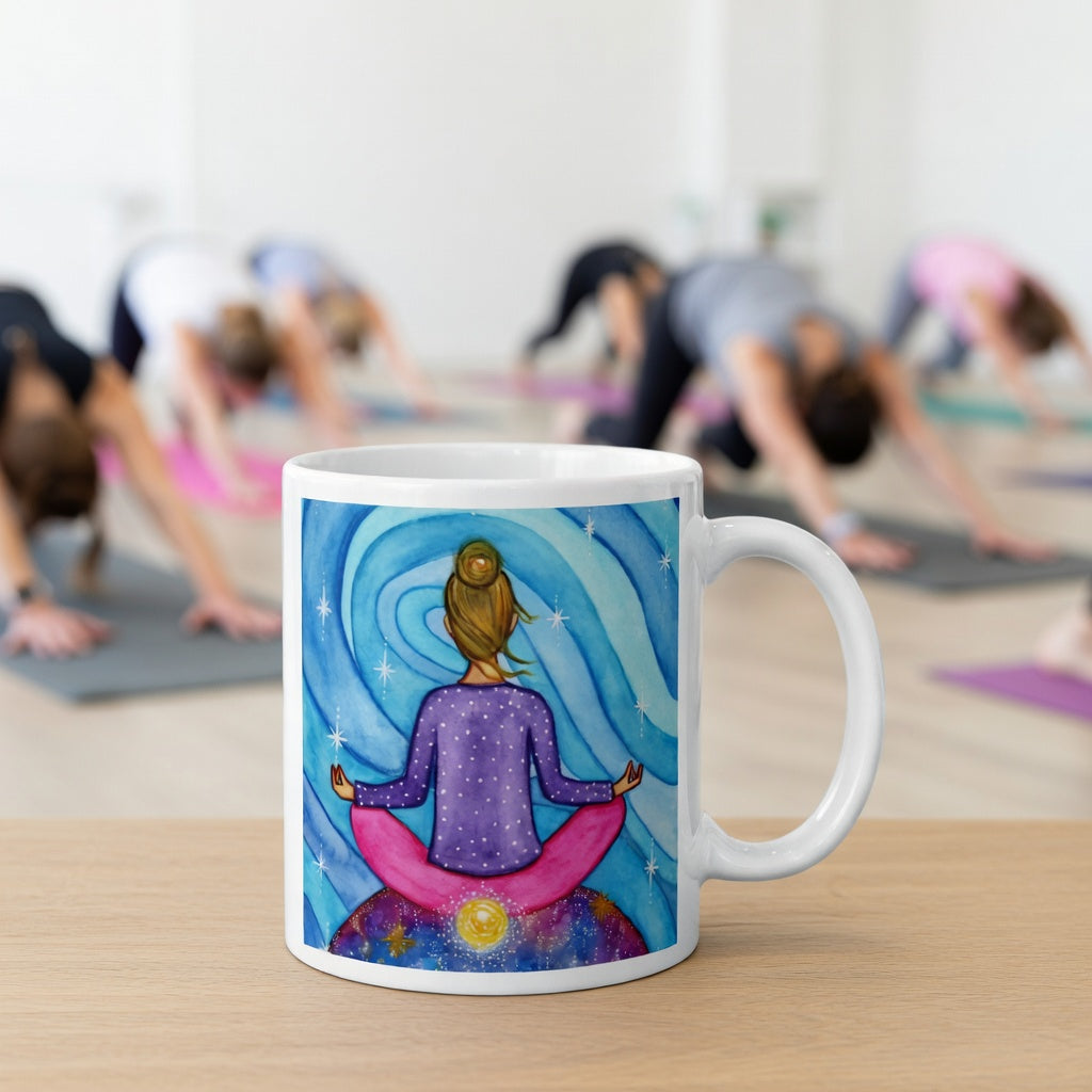 Meditating figure with glowing root chakra at base of spine, symbolizing grounding, stability and security, chakra energy artwork on a coffee mug. The mug is in front of a yoga class doing the downward facing dog posture.