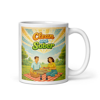 Mug with a design of two people having a picnic and the text 'Clean and Sober' on a white background.