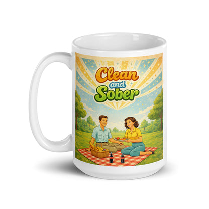 Mug with a design of two people having a picnic and the text 'Clean and Sober' on a white background. Celebrating sobriety.