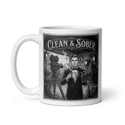Lovely and intriguing Black and white vintage illustration coffee mug featuring a tuxedo-clad man on a 1920s silent film set holding a steaming coffee mug and a clapperboard reading "Breaking Free" surrounded by period cameras and studio lights with "Clean & Sober" in marquee lettering