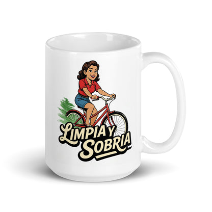 Diseño retro en español para taza de café con mujer sonriente andando en bicicleta y texto “Limpia y Sobria”, inspirado en la recuperación, libertad y vida saludable sin alcohol.