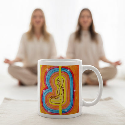 Woman surrounded by radiant multi-colored aura, representing energy, emotion and spiritual awareness, vibrant mindfulness artwork on a coffee mug.   A large mug is at the bottom front displaying the design. There is a couple meditating in the background.