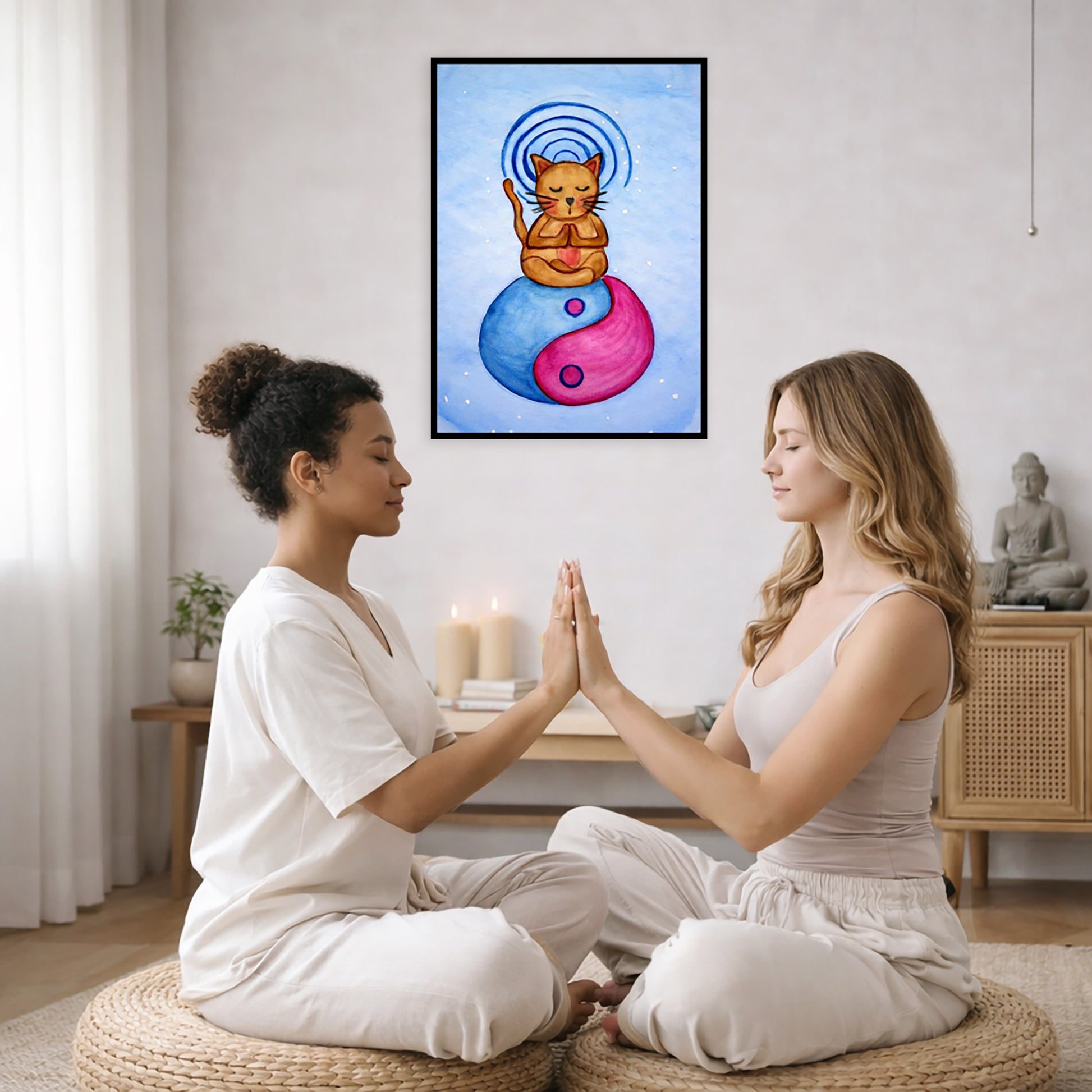 Brown cat meditating on a yin yang symbol with its crown chakra glowing framed poster.  This is a print of the original hand-painted watercolor by Brazilian artist Thaís Suizo. The poster is in the center of the living room wall. Two women are sitting on wicker pillows face to face with their hands pressing against one another, transferring healing energy. Behind them is a coffee table with two burning candles, some books and a potted plant. To the left is a cabinet with a Buddha statue on it.