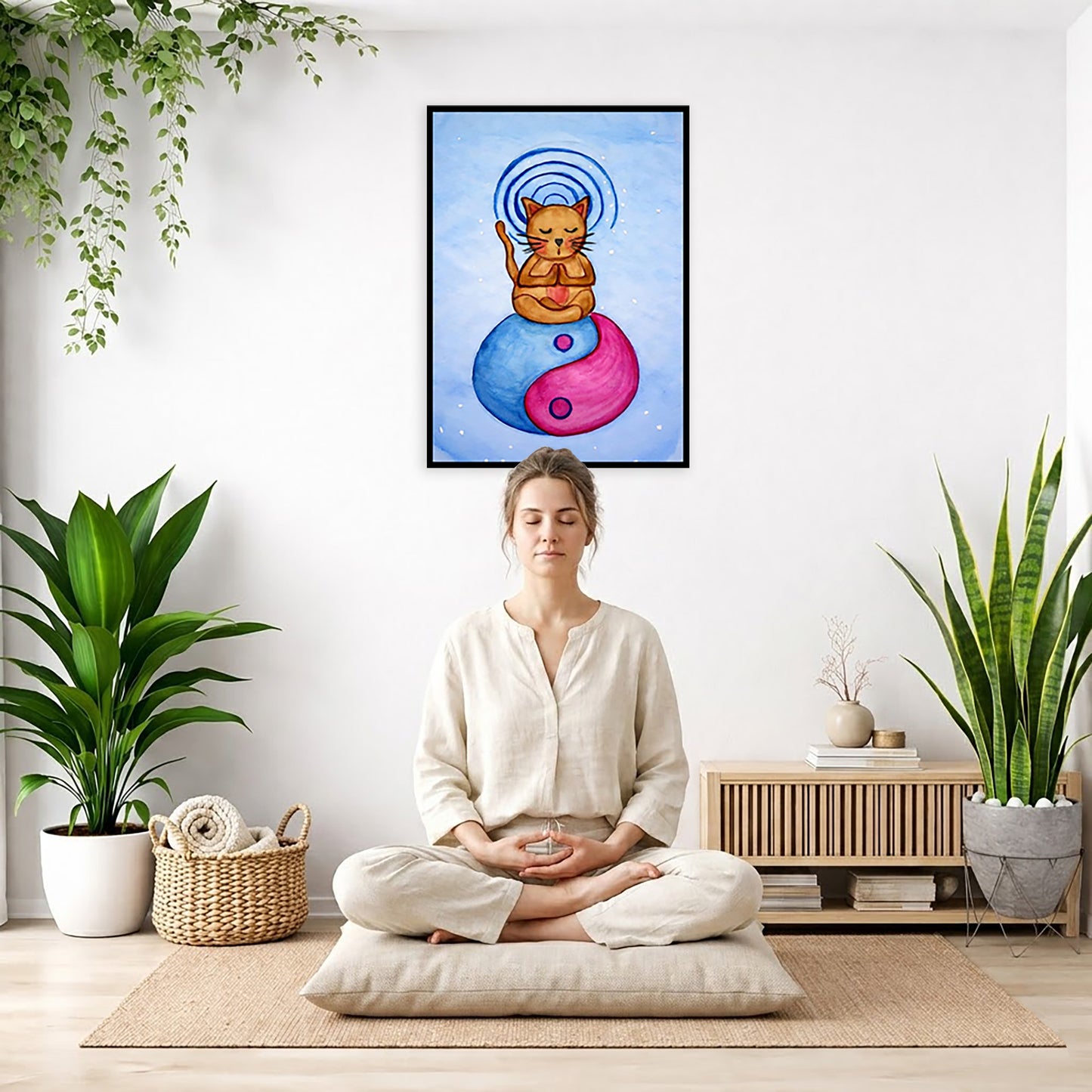 Brown cat meditating on a yin yang symbol with its crown chakra glowing framed poster.  This is a print of the original hand-painted watercolor by Brazilian artist Thaís Suizo.  The poster is in the center of the living room wall. There is a woman meditating facing away from the wall. Behind her is a coffee table with incense and a Buddha statue. There are potted plants on the right and left side of the background.

