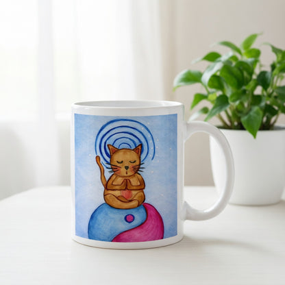 Brown cat meditating on top of a blue and magenta Tao symbol with a glowing crown chakra above its head meditation mug.  There is a window, curtains and a green potted plant behind the mug.