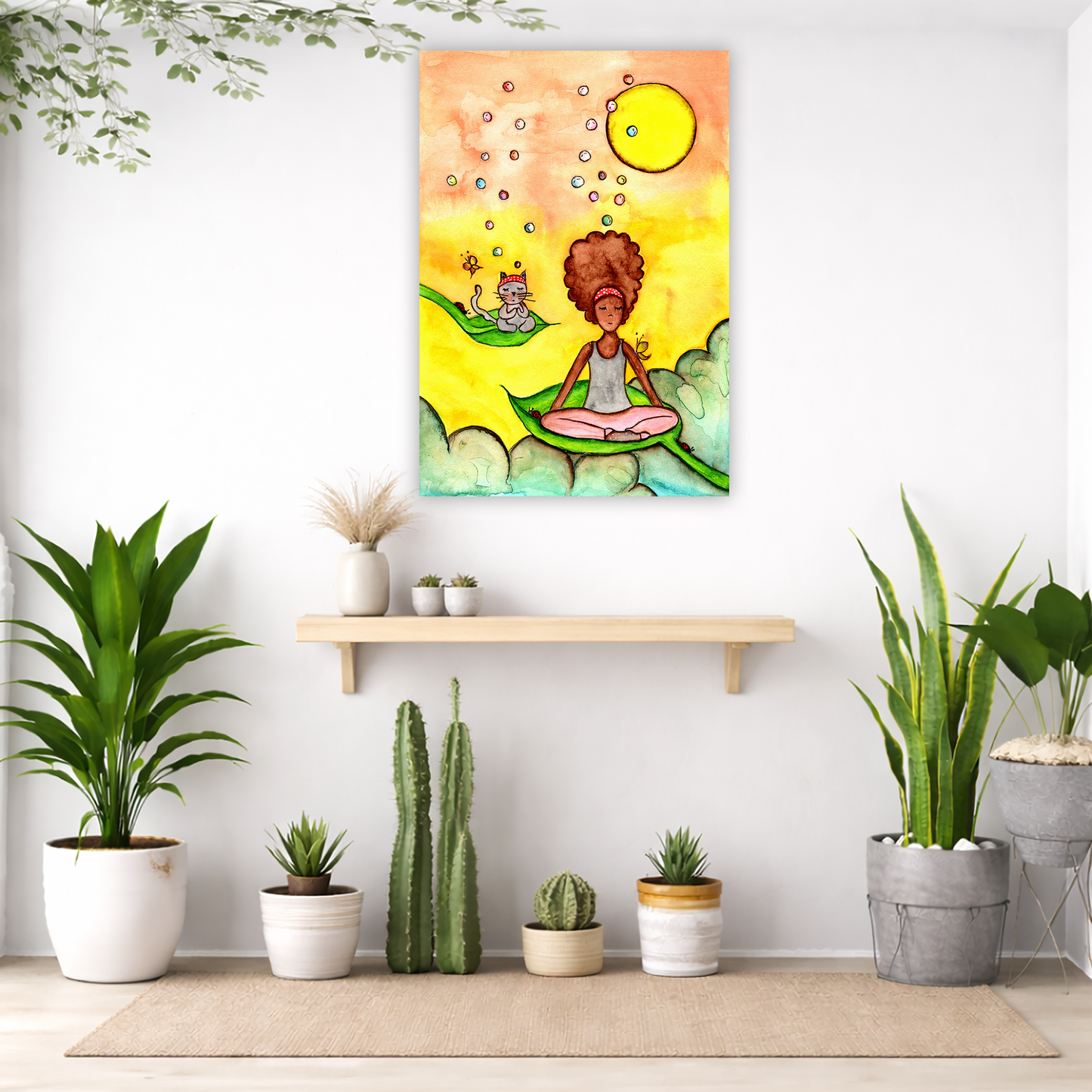 Canvas of a woman and her cat meditating while sitting on leaves. The background is bright yellow.  The canvas is in the center of the living room wall. Below the poster is an empty bench. Below the bench is a variety of green potted plants including a few cactus.

