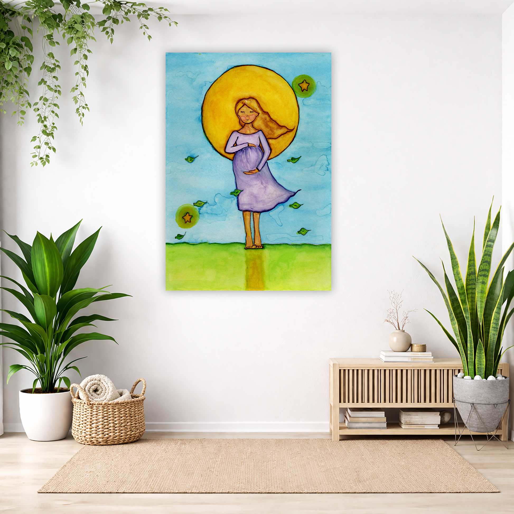 A woman standing in meditation under a bright yellow sun with a blue sky background, canvas watercolor print.  The canvas is in the center of the living room wall. Below the poster to the left is a basket of material and a green floor plant. There is also a green hanging plant. To the right is a small table with books, a candle and a vase with dry flora. There is also a large green floor plant.