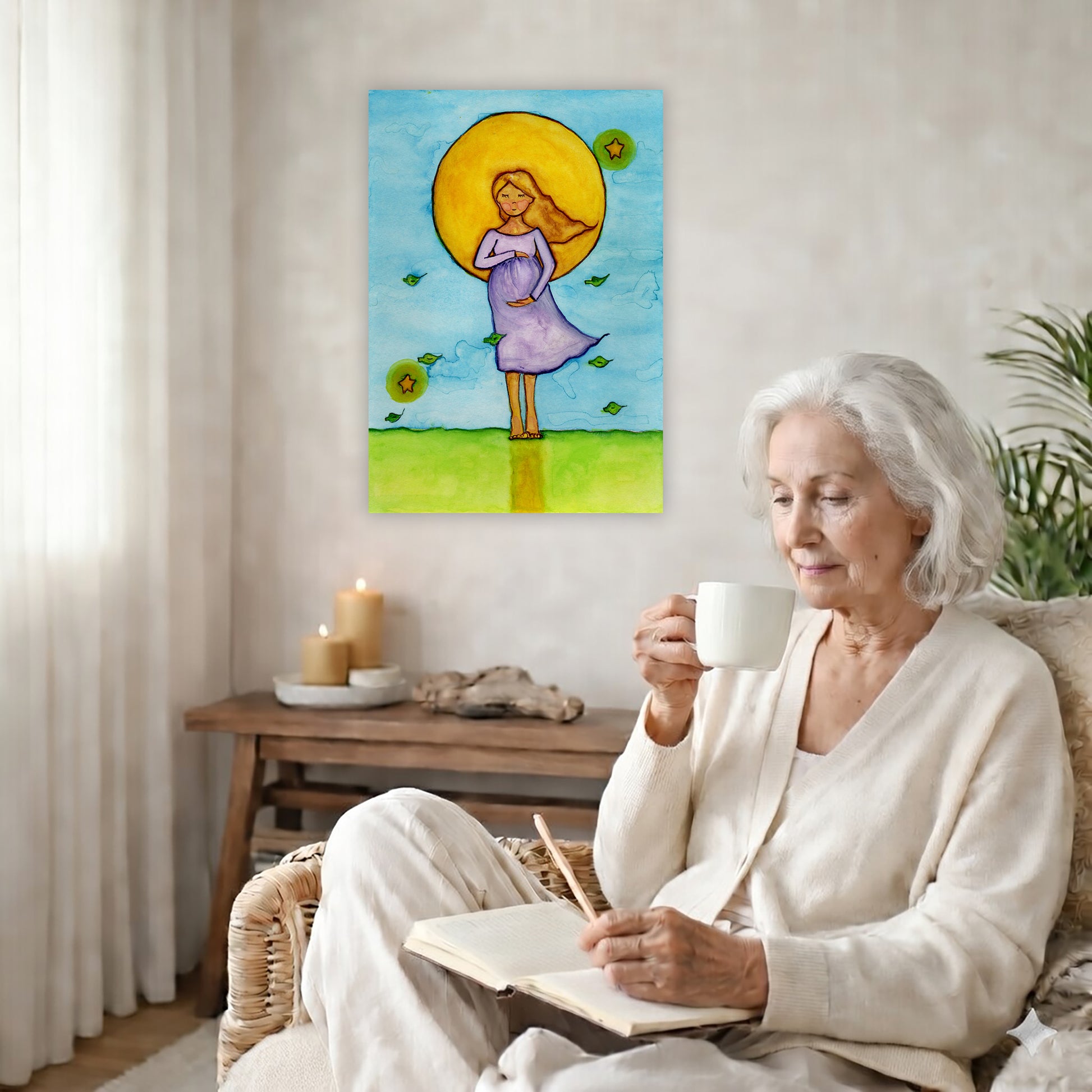 A woman standing in meditation under a bright yellow sun with a blue sky background, canvas watercolor print. The canvas is in the center of the living room wall. There is a coffee table below the poster with burning candles. A woman is sitting in a wicker chair on the right side of the poster with a cup of tea writing in her journal.
