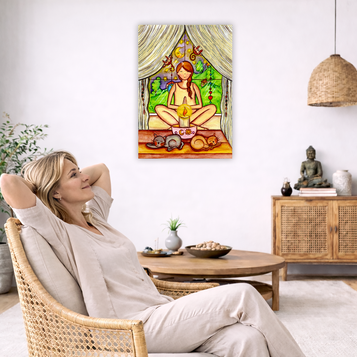 A woman candlelight trataka meditation design on mindfulness canvas. The canvas is in the center of the living room wall. To the left a woman is relaxing in her chair with her hands behind her head. There is a small coffee table beside her with a bowl of walnuts, incense and a small green plant. On the right side of the room is a cabinet with a Buddha statue, books and an urn on it. To the left is a green floor plant.
