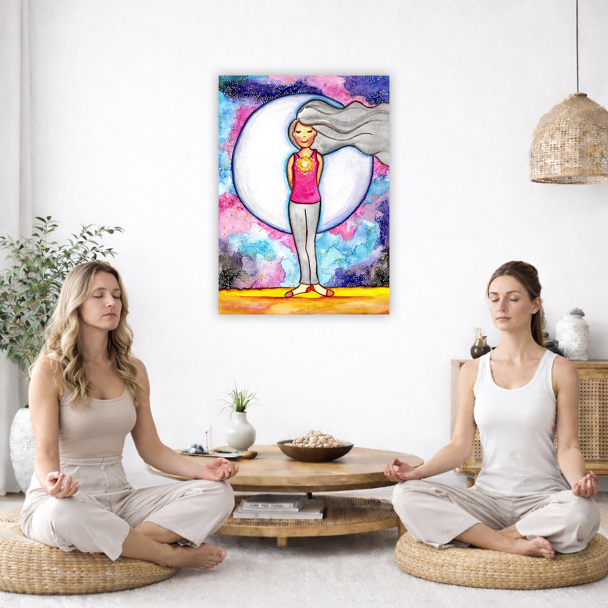 Poster of a woman's heart chakra glowing with love energy.  The poster is in the center of the living room wall. Two women are sitting on a giant pillow having a coffee. Beside them is a small tray with a pot of coffee and incense. To the left is a green floor plant and a hanging green plant. To the right of them is a green floor plant.