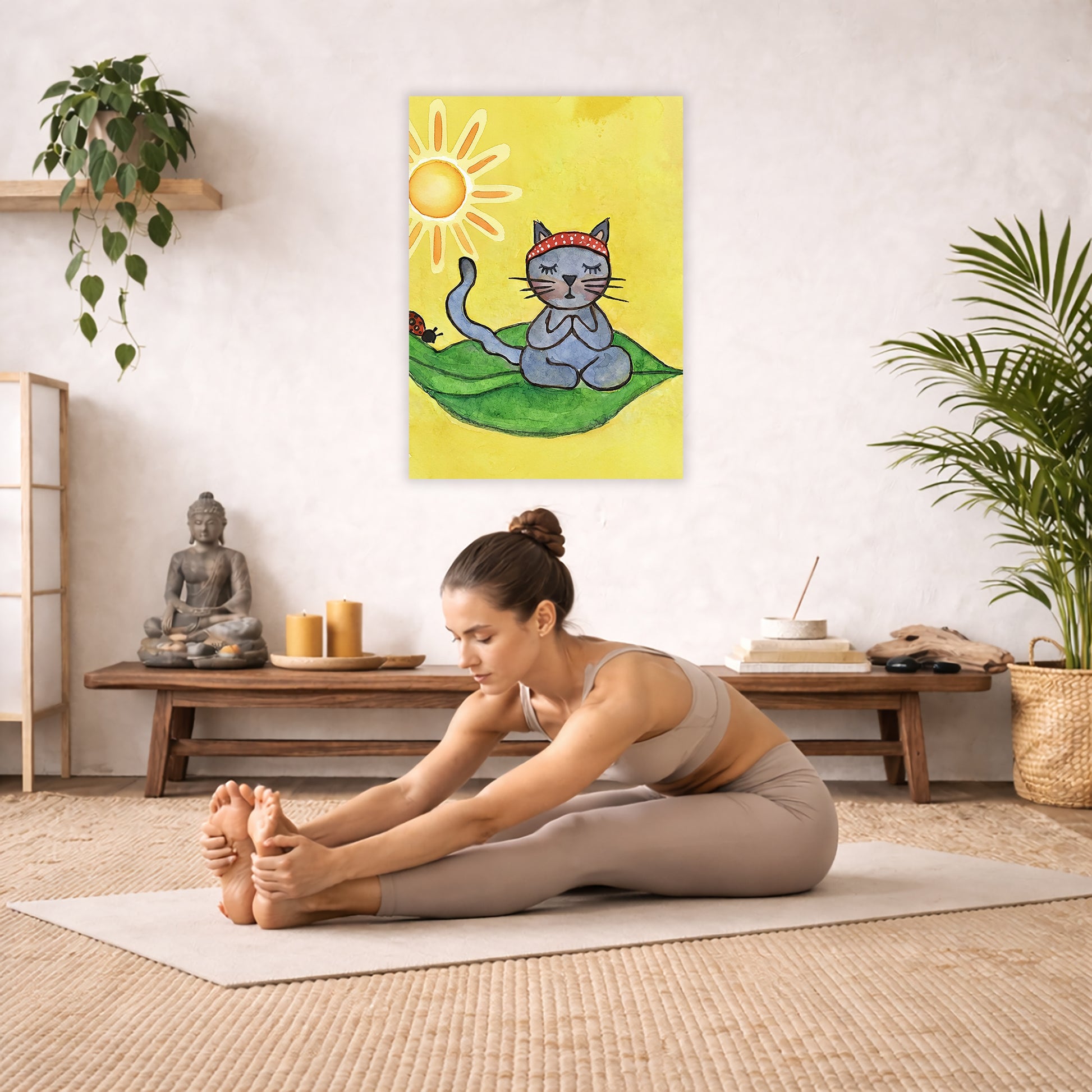 Gray cat meditating on a leaf in sunlight, peaceful nature-inspired mindfulness artwork. The poster is hanging in the middle of the living room wall. A woman is doing the seated forward bend yoga pose in front of the poster. Behind her is a coffee table with incense and a Buddha statue. There are potted plants on the right and left side of the background.
