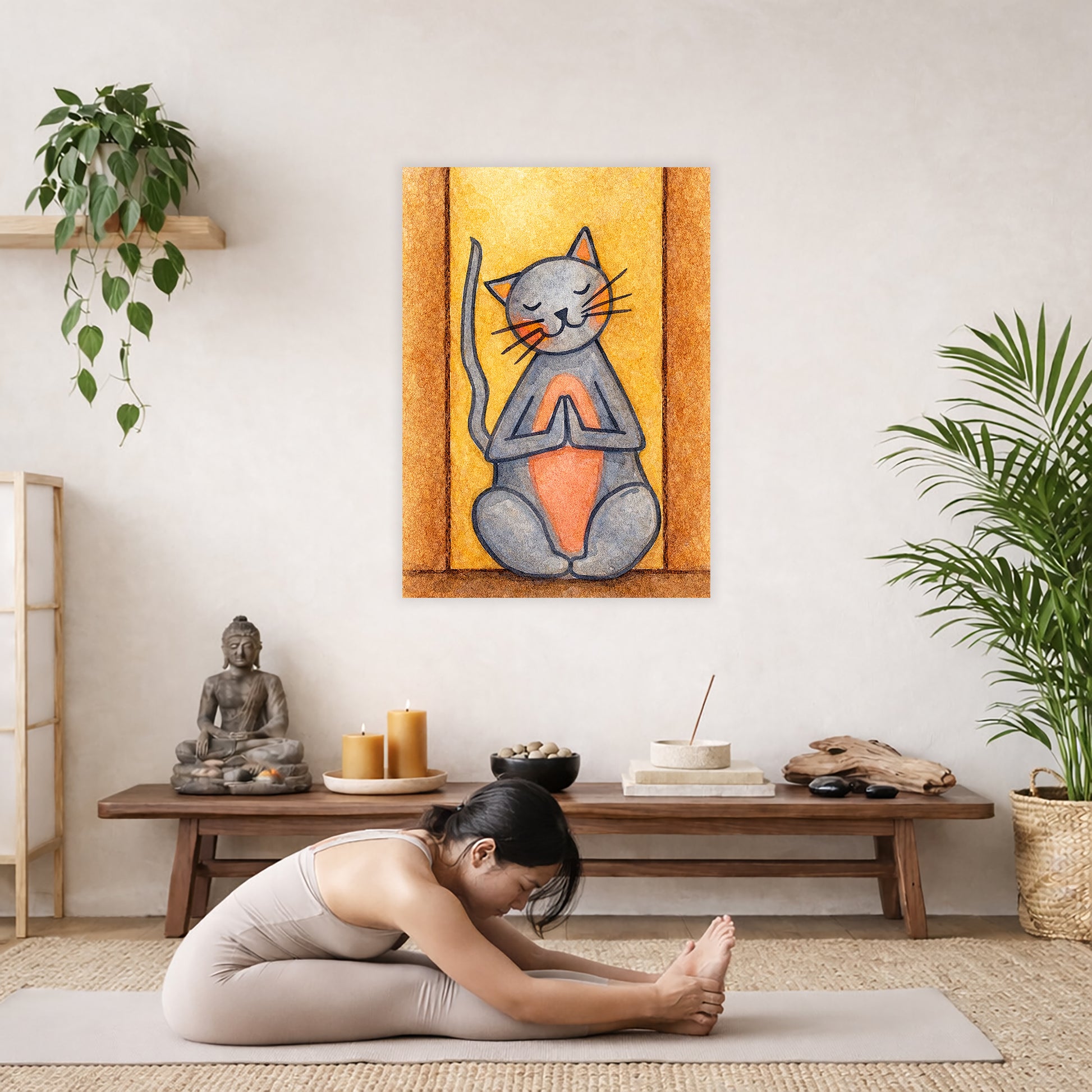 Poster of gray cat with a pink belly sitting in meditation, cute and calming illustration. The poster is hanging in the middle of the living room wall. A woman is doing the seated forward bend yoga pose in front of the poster. Behind her is a coffee table with incense and a Buddha statue. There are potted plants on the right and left side of the background.
