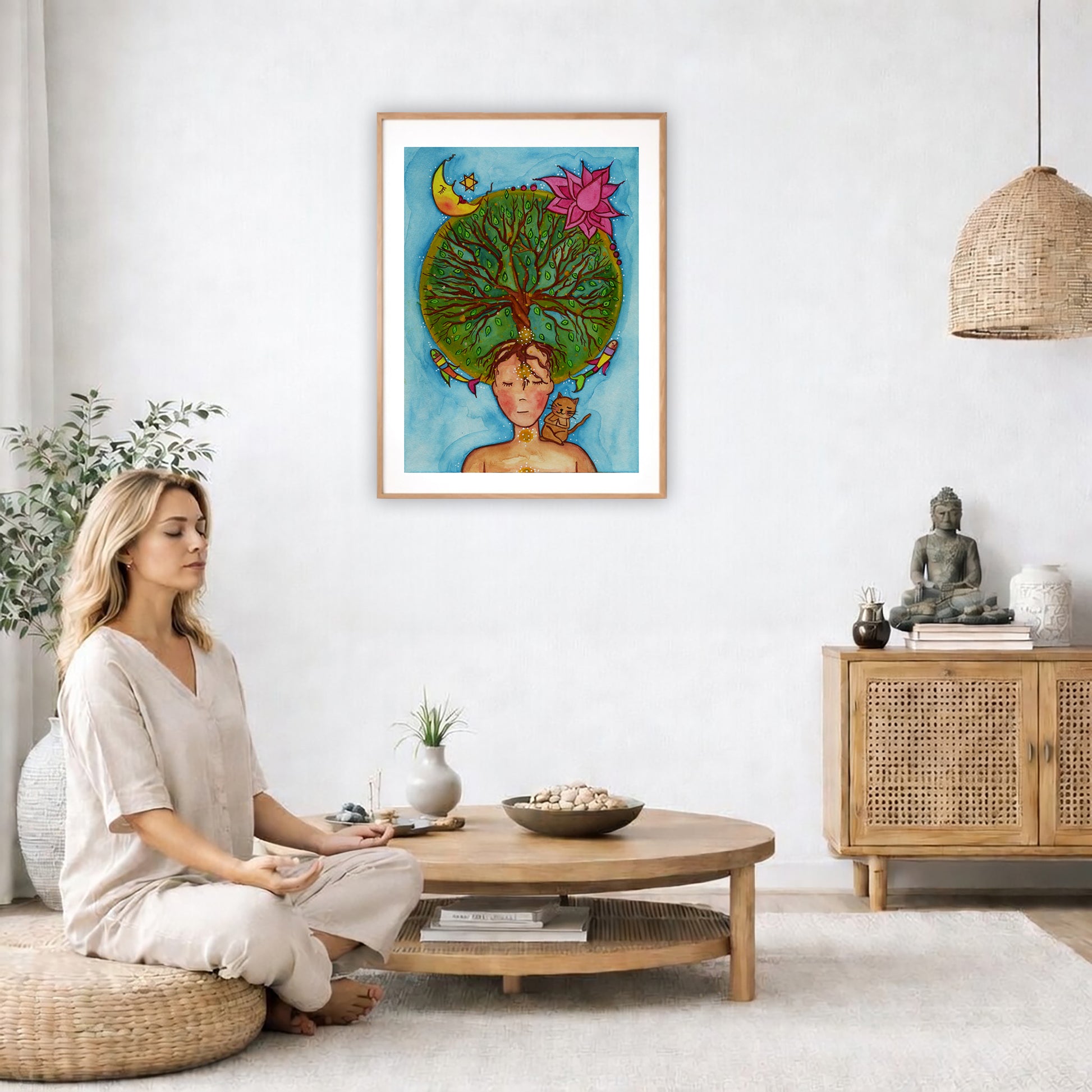 Poster of the crown chakra of a woman opening up like the tree of life. A cat is on her shoulder.  The poster is in the center of the living room wall. A woman is on a chair on the left side of his living room meditating. There is a green potted plant behind her. On the right side is a cabinet with a Buddha statue on it.
