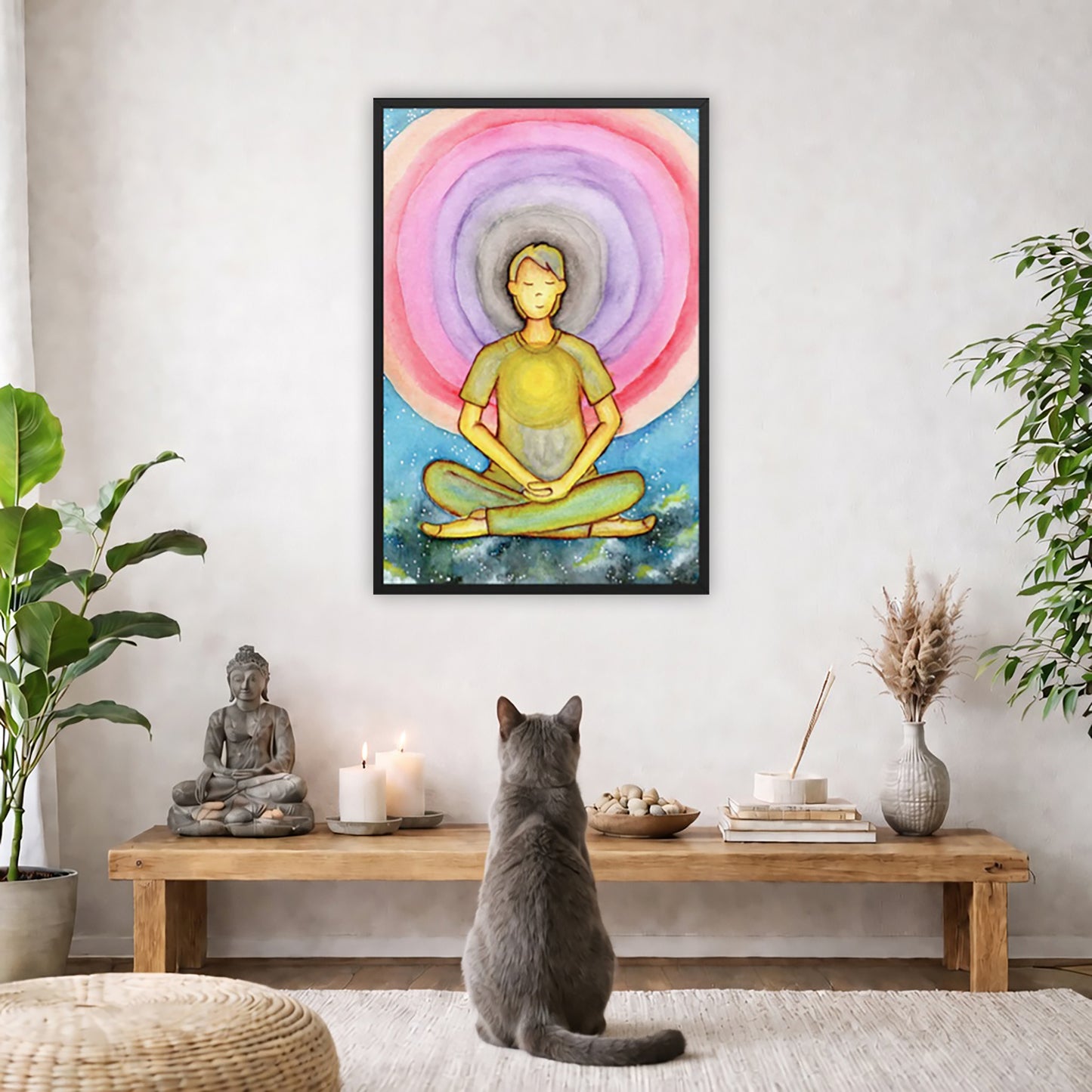 Framed poster of a man's heart chakra glowing and the colorful aura energy surrounding him. The poster is in the center of the living room wall. A gray cat is facing the poster. In front of it is a coffee table with a Buddha statue and burning candle on the left and incense and an orange cat staring at the poster on the right. There is a green potted plant on both the left and right side of the coffee table.