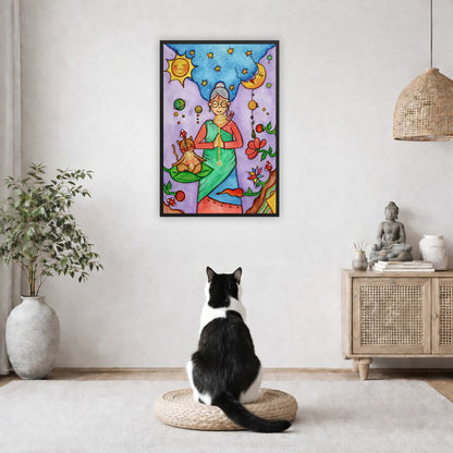 Framed poster of woman in standing prayer meditation with glowing throat chakra under sun and moon. Her cat is meditating beside her.  The poster is in the center of the living room wall. A black and white cat is staring at the poster. There is a potted plant on the left side and a cabinet with a Buddha statue on it on the right side. 

