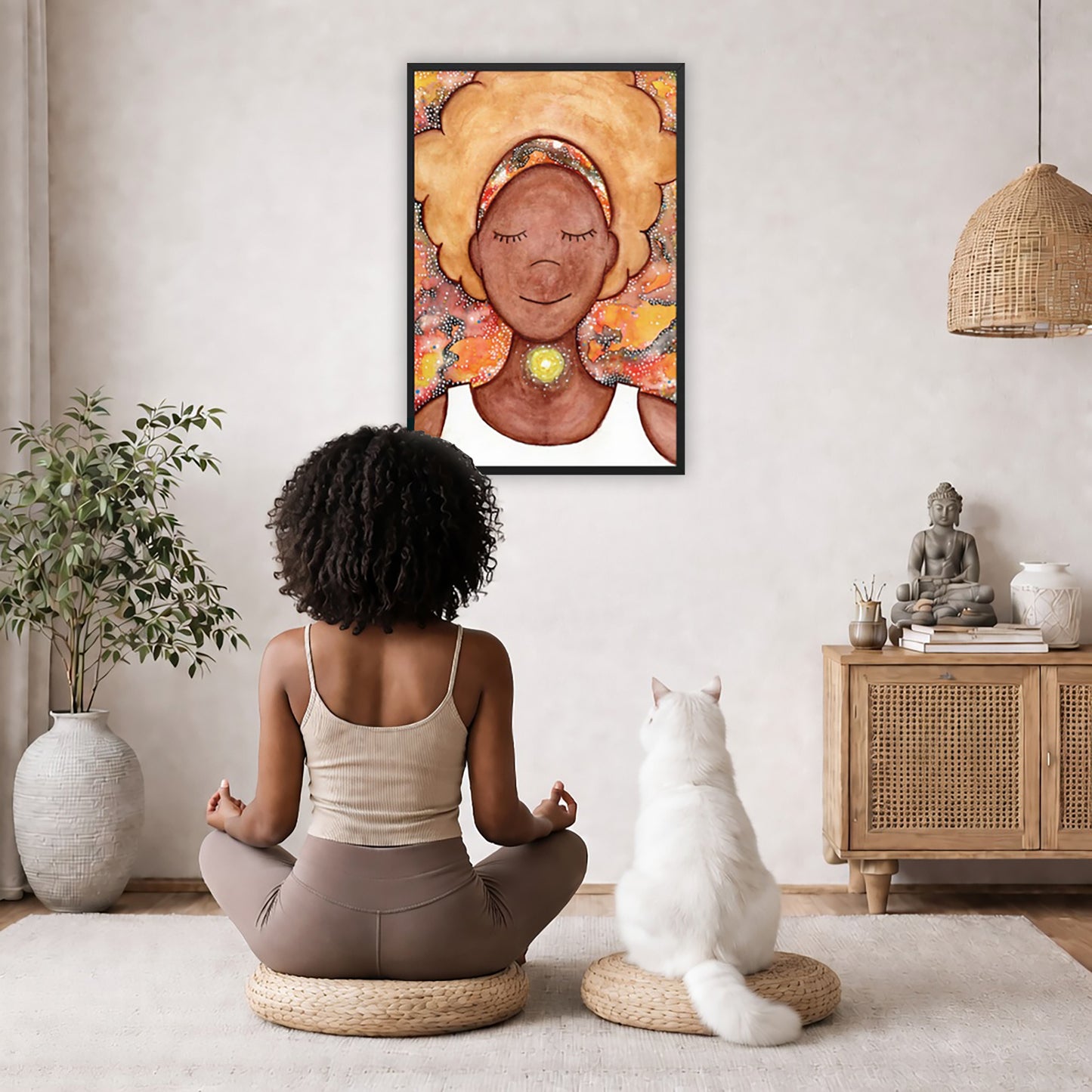 Framed poster of a woman mediating with a glowing throat chakra. The poster is in the center of the living room wall. A woman and a cat are staring up at the poster. There is a potted plant on the left side and a cabinet with a Buddha statue, books and incense on the right side. 