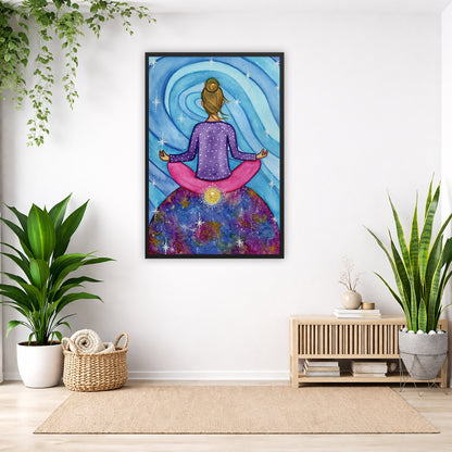 Framed poster of a woman meditating on top of the world with her root chakra glowing.  The poster is in the center of the living room wall. Below the poster to the left is a basket of material and a green floor plant. There is also a green hanging plant. To the right is a small table with books, a candle and a vase with dry flora. There is also a large green floor plant.