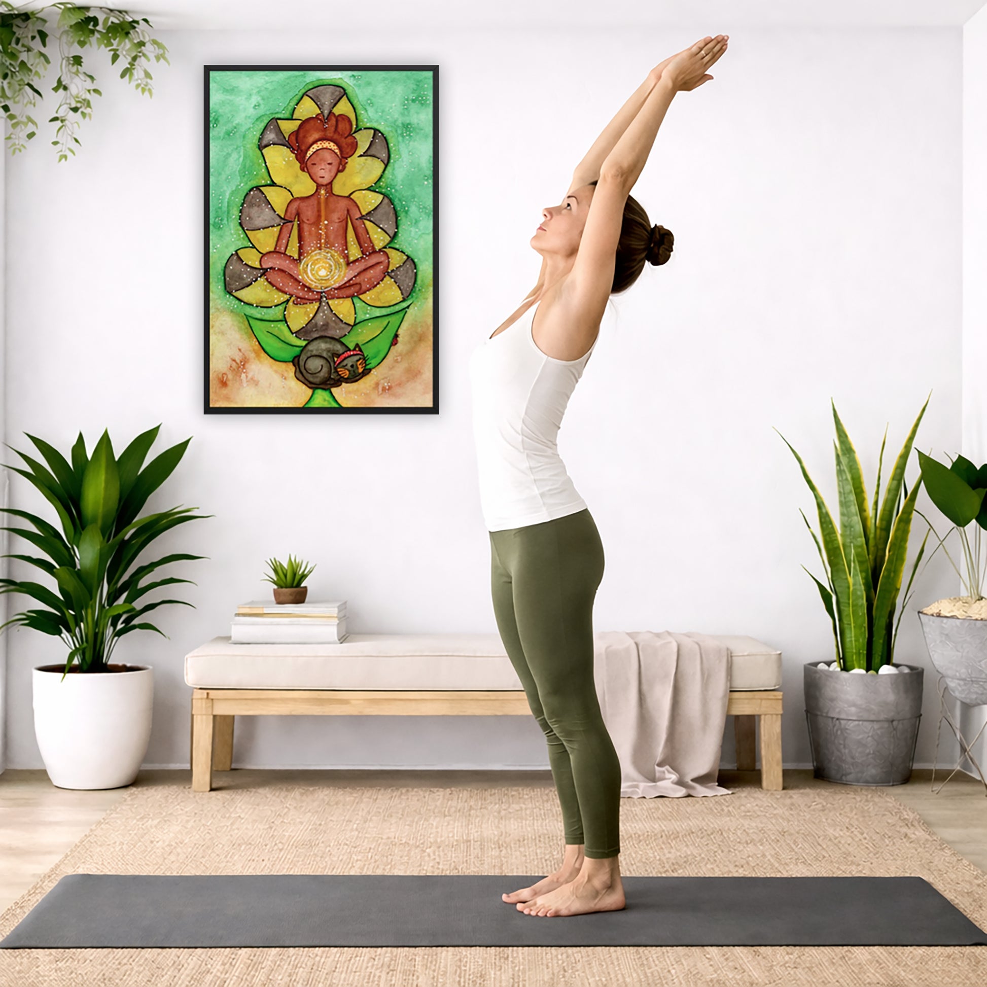 Poster of a woman's sacral chakra glowing and the energy around her.  The poster is in the center of the living room wall. A woman is doing a sun salutation on her yoga mat. There is a coffee table below the poster with burning candles, incense, a Buddha statue and a big piece of driftwood.
