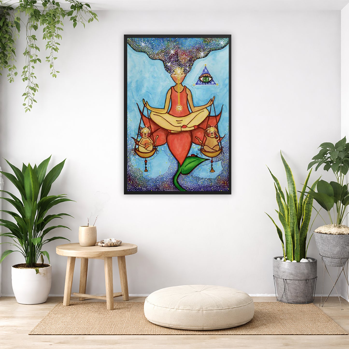 Framed poster of a woman sitting on a lotus with a glowing brow chakra holding a large set of scales.  The poster is in the center of the living room wall. Below the poster is a pillow on a wicker mat. To the bottom left there is a small table with incense and a bowl of shells. There is also a hanging and potted plant. To the right are two potted green plants.
