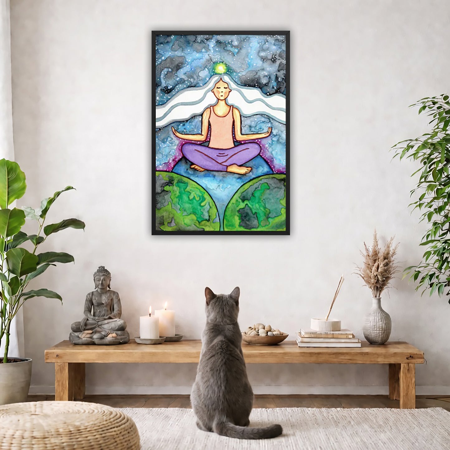 Framed poster of a meditating woman with her crown chakra glowing.  The poster is in the center of the living room wall. A gray cat is facing the poster. In front of it is a coffee table with a Buddha statue and burning candle on the left and incense and an orange cat staring at the poster on the right. There is a green potted plant on both the left and right side of the coffee table.