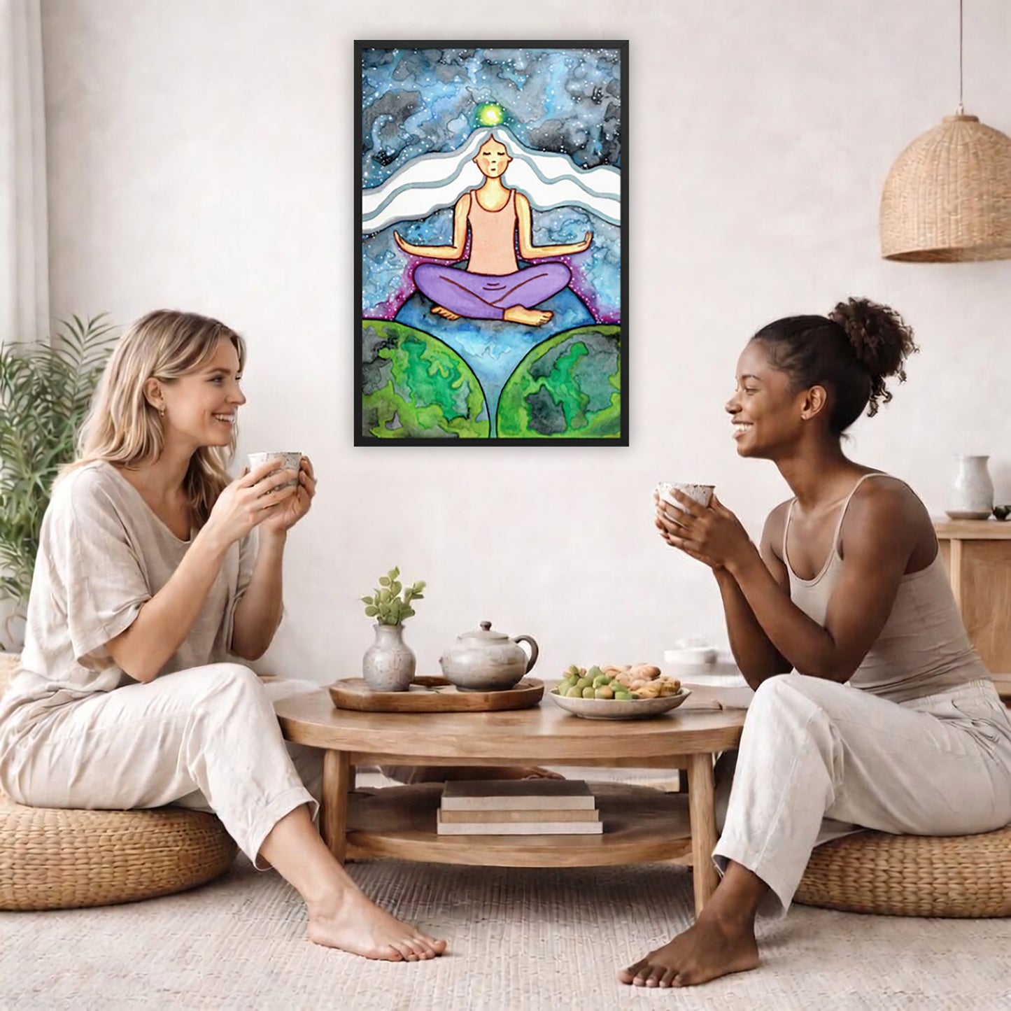 Framed poster of a meditating woman with her crown chakra glowing.  The poster is in the center of the living room wall. Two female friends are sitting on a white couch having tea. On the left and rights sides there is a green potted plant.
