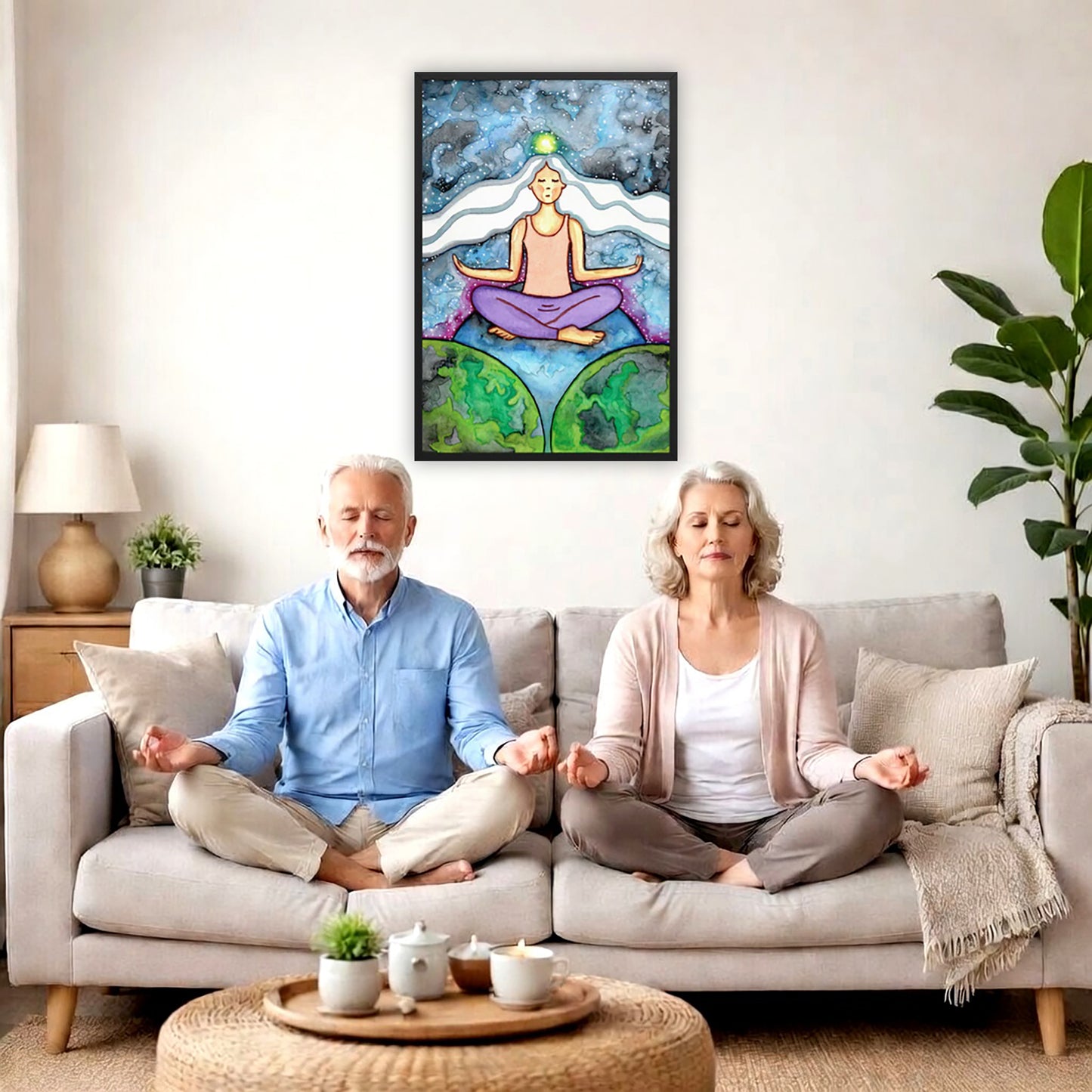 Framed poster of a meditating woman with her crown chakra glowing. A couple is meditating on their couch. The poster is framed on a wall behind them. There is a coffee table in front with candles burning and a potted plant. There is a potted plant to the right and shelves on the left.

