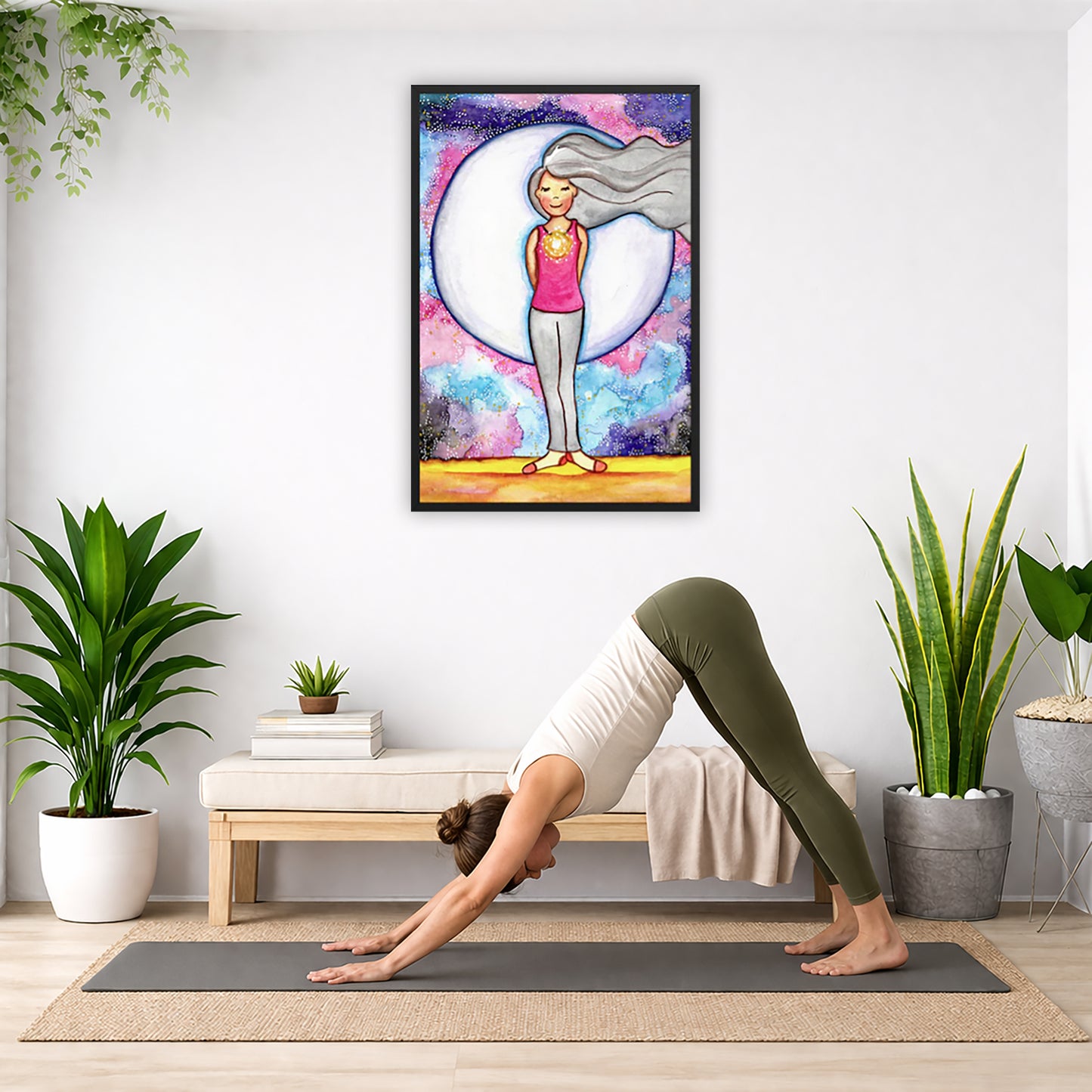 Framed poster of a woman's heart chakra glowing with beautiful love energy. The poster is in the center of the living room wall. A woman is doing a sun salutation on her yoga mat. There is a coffee table below the poster with burning candles, incense, a Buddha statue and a big piece of driftwood.
