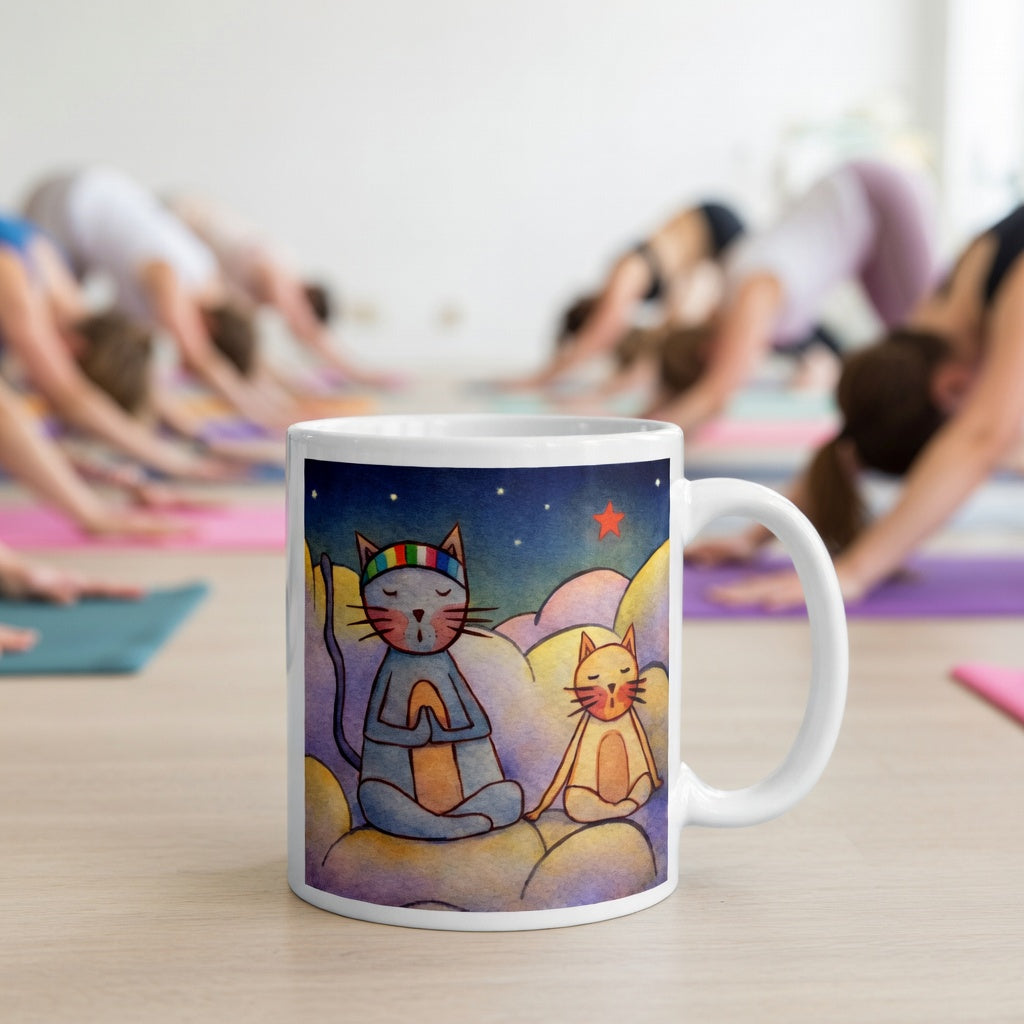 Two cats meditating on a cloud under the night sky mindfulness mug. The mug is in front of a yoga class doing the downward facing dog posture.