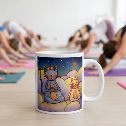 Two cats meditating on a cloud under the night sky mindfulness mug. The mug is in front of a yoga class doing the downward facing dog posture.