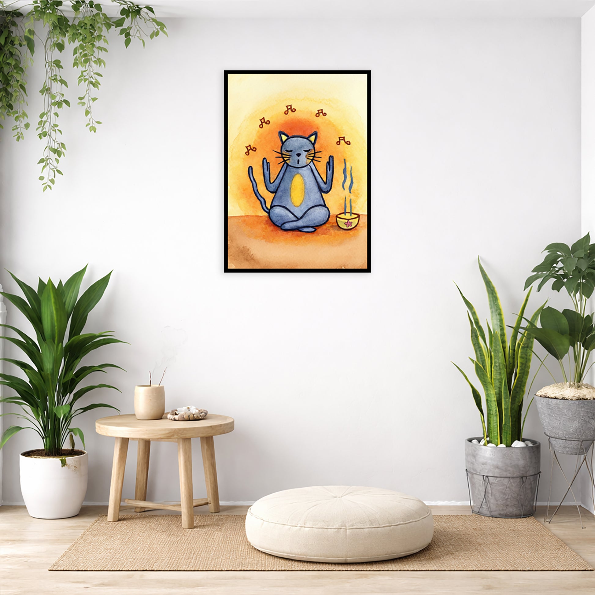 Gray cat chants with incense burning framed poster.  This is a print of the original hand-painted watercolor by Brazilian artist Thaís Suizo.  The poster is in the center of the living room wall. Below the poster is a pillow on a wicker mat. To the bottom left there is a small table with incense and a bowl of shells. There is also a hanging and potted plant. To the right are two potted green plants.
