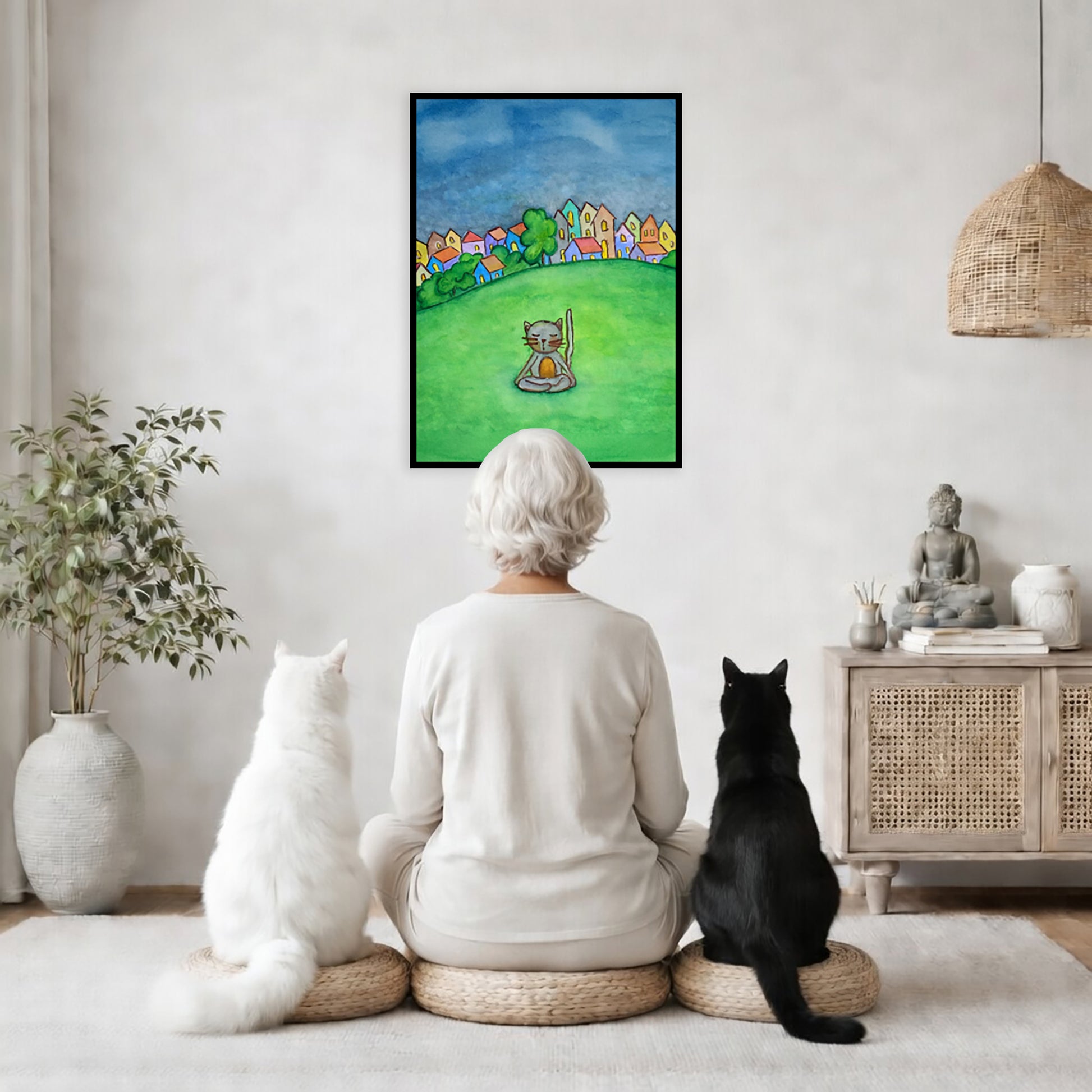 A gray cat meditating in the park framed poster. This is a print of the original hand-painted watercolor by Brazilian artist Thaís Suizo.  The poster is in the center of the living room wall. A woman is meditating facing the poster with a white cat on her left side and a black cat on her right side. There is a potted plant on the left side and a cabinet with a Buddha statue on it on the right side. 

