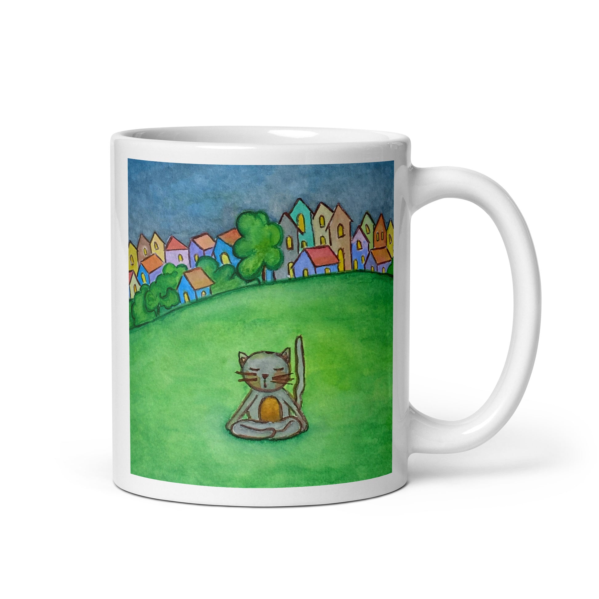Gray cat meditating peacefully in a park surrounded by a large lawn and a row of houses in the distant background coffee mug. This illustration of a cat meditating is on both sides of the mug. In this image the handle of the mug is on the right side.