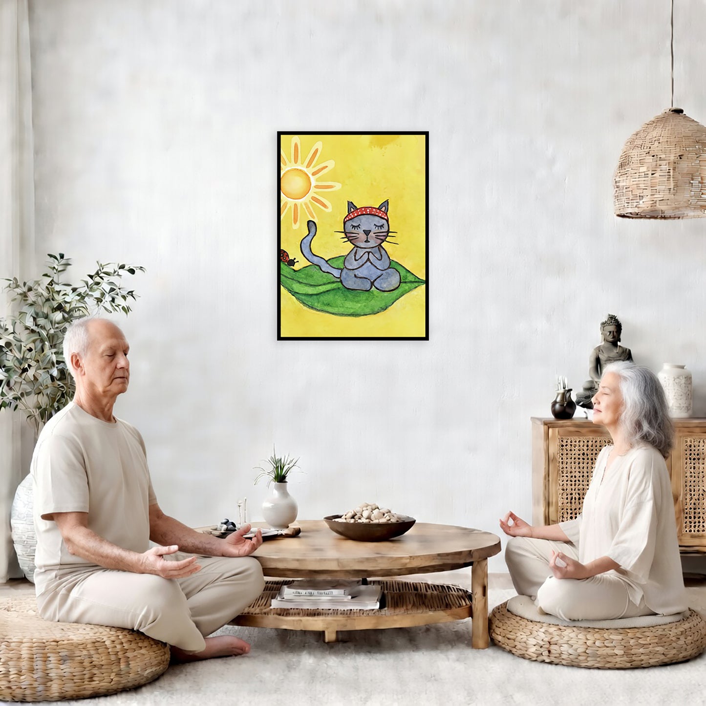 Gray cat meditating on a leaf under a sunny sky framed poster. This is a print of the original hand-painted watercolor by Brazilian artist Thaís Suizo.  The poster is in the center of the living room wall. Two friends are sitting on wicker pillows meditating. Between them is a small round coffee table with incense, a green potted plant and a bowl of shells. There is a potted plant to the left and a Buddha statue and a vase to the right.