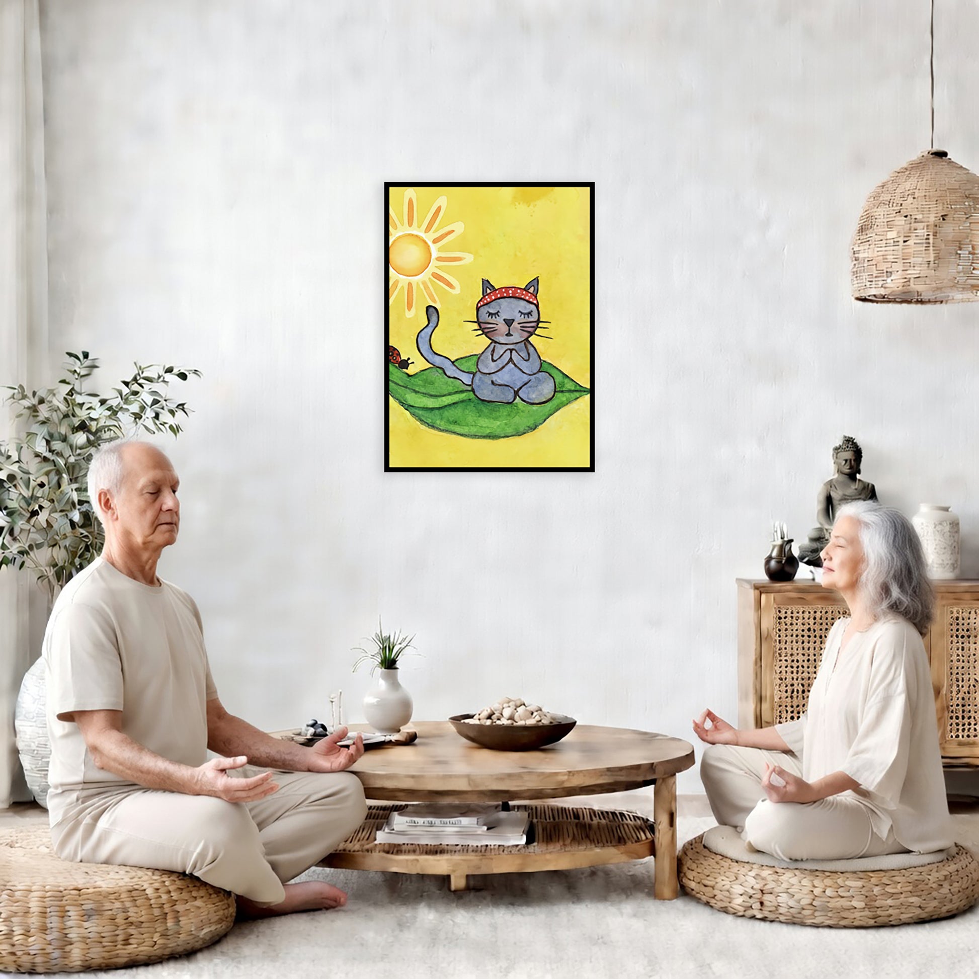 Gray cat meditating on a leaf under a sunny sky framed poster. This is a print of the original hand-painted watercolor by Brazilian artist Thaís Suizo.  The poster is in the center of the living room wall. Two friends are sitting on wicker pillows meditating. Between them is a small round coffee table with incense, a green potted plant and a bowl of shells. There is a potted plant to the left and a Buddha statue and a vase to the right.