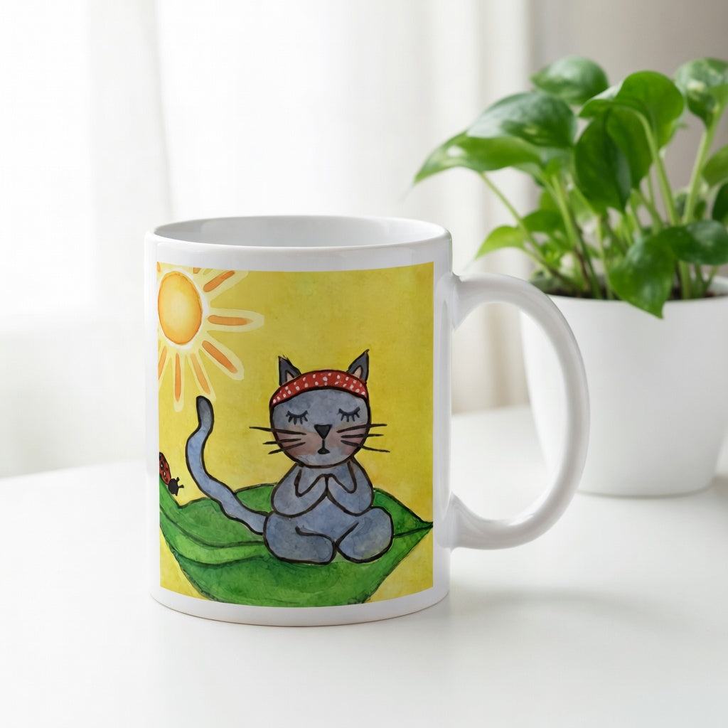 Gray cat meditating peacefully on a leaf in the bright sunlight meditation mug.  There is a window, curtains and a green potted plant behind the mug.