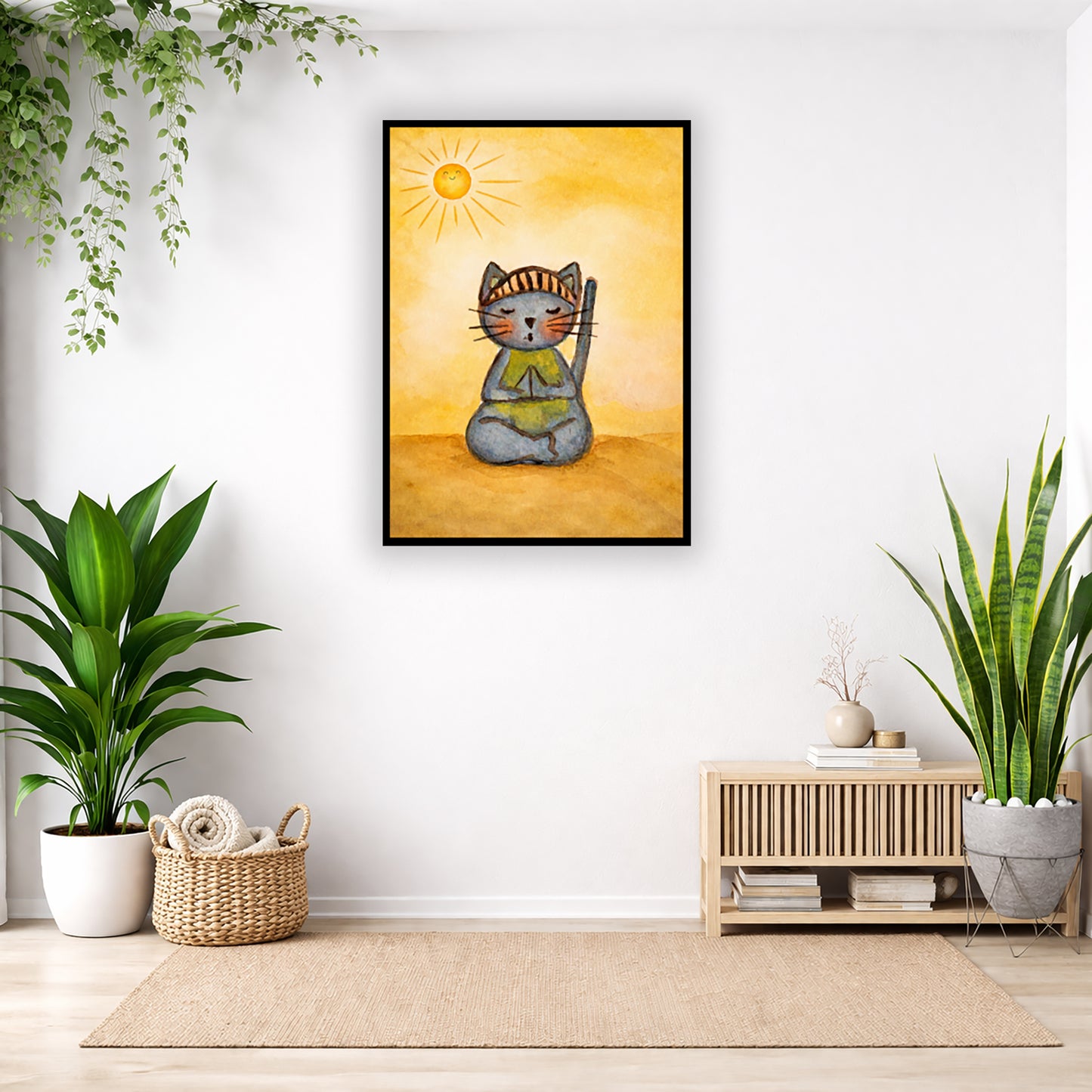 A gray cat meditating on a sunny day framed poster.  This is a print of the original hand-painted watercolor by Brazilian artist Thaís Suizo. The poster is in the center of the living room wall. Below the poster to the left is a basket of material and a green floor plant. There is also a green hanging plant. To the right is a small table with books, a candle and a vase with dry flora. There is also a large green floor plant.