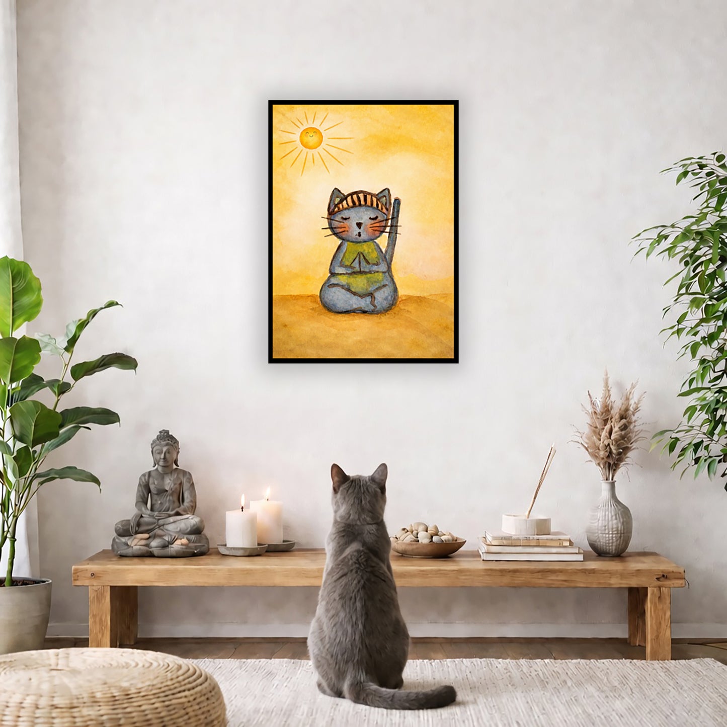 A gray cat meditating on a sunny day framed poster.  This is a print of the original hand-painted watercolor by Brazilian artist Thaís Suizo. The poster is in the center of the living room wall. A gray cat is facing the poster. In front of it is a coffee table with a Buddha statue and burning candle on the left and incense and an orange cat staring at the poster on the right. There is a green potted plant on both the left and right side of the coffee table.

