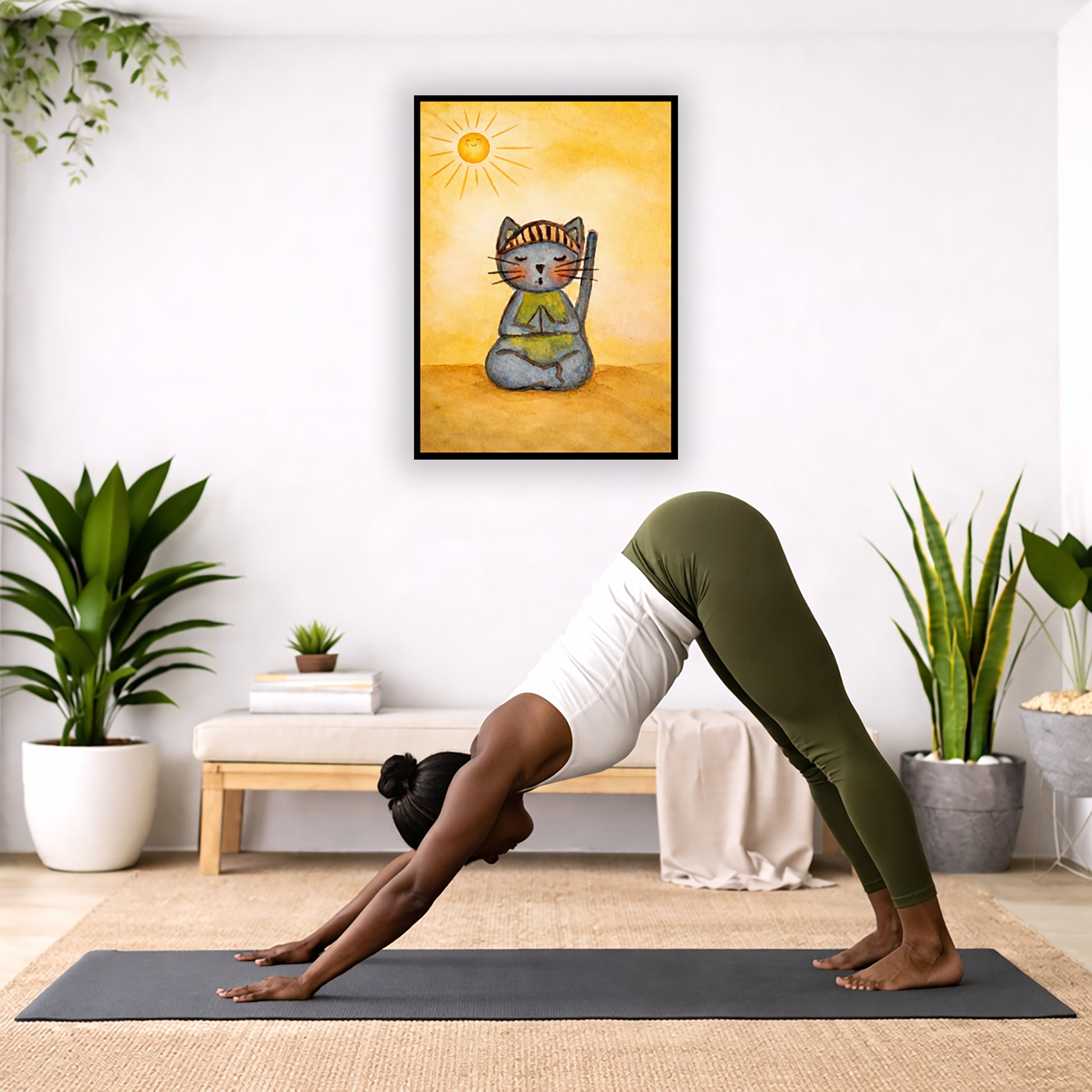 A gray cat meditating on a sunny day framed poster.  This is a print of the original hand-painted watercolor by Brazilian artist Thaís Suizo.  The poster is in the center of the living room wall. Below the poster a woman is doing the yoga posture downward facing dog on a yoga mat.

