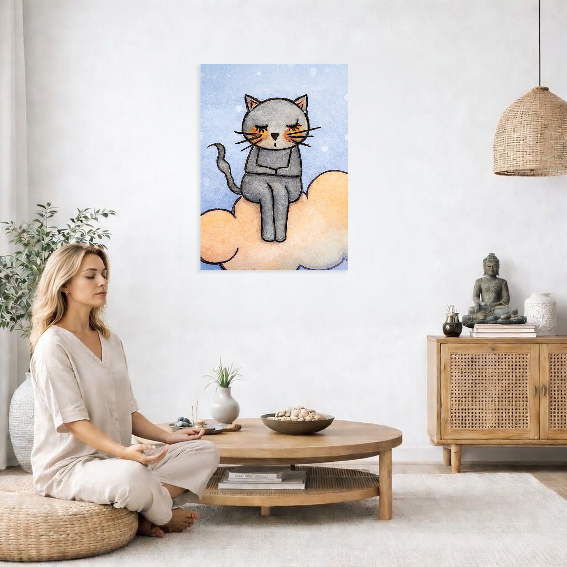 Gray cat meditating on a pink cloud canvas poster. This is a print of the original hand-painted watercolor by Brazilian artist Thaís Suizo for the LET'S MEDITATE SERIES of mediation guides.  The poster is in the center of the living room wall. A woman is on a chair on the left side of his living room meditating. There is a green potted plant behind her. On the right side is a cabinet with a Buddha statue on it.
