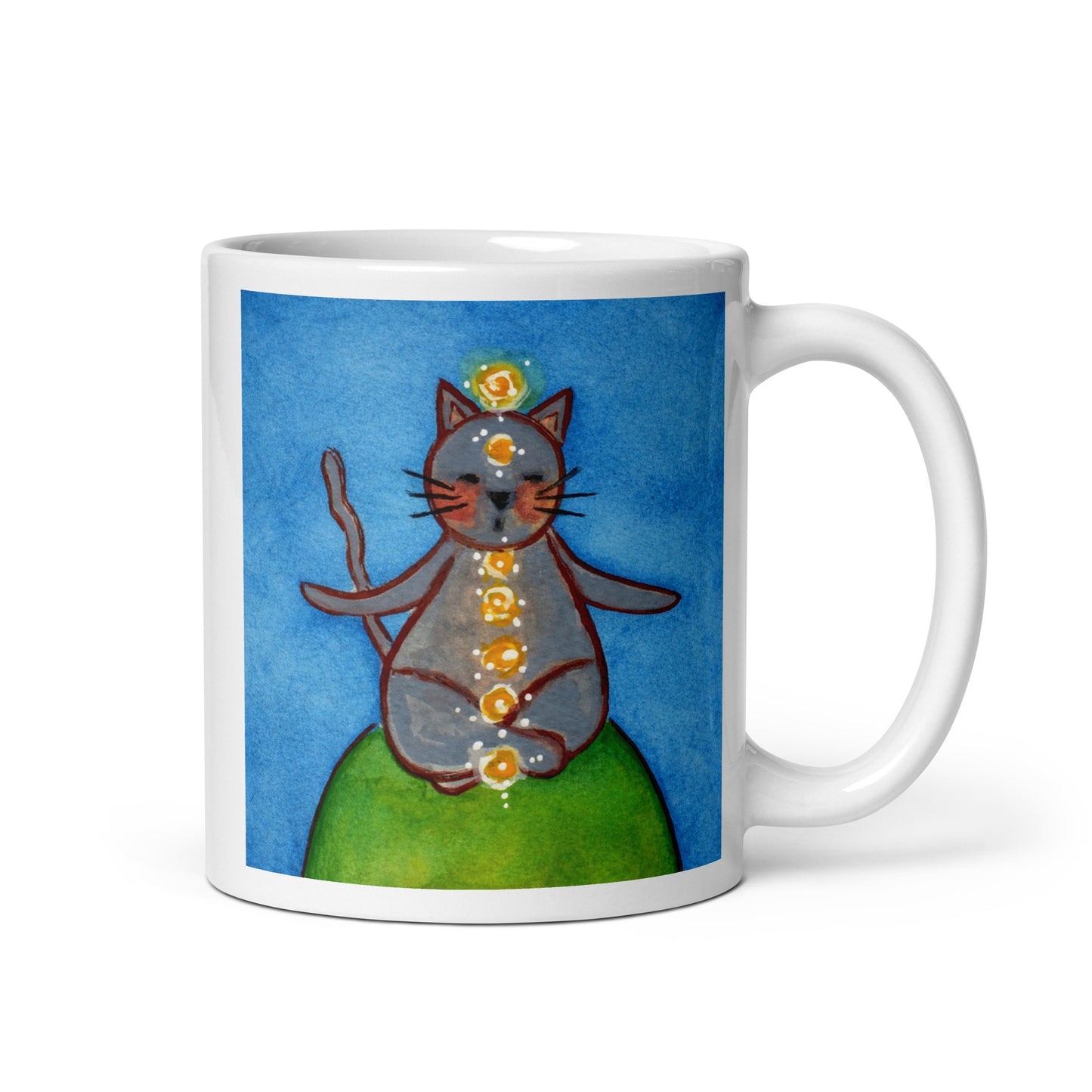 Gray cat meditating with glowing chakras on a deep blue calming background. This illustration of a cat meditating is on both sides of the mug. In this image the handle of the mug is on the right side.