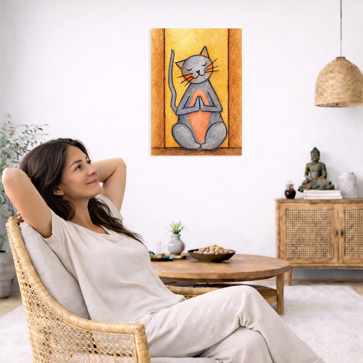 Woman relaxing in a wicker chair with a painting of a meditating cat on the wall.