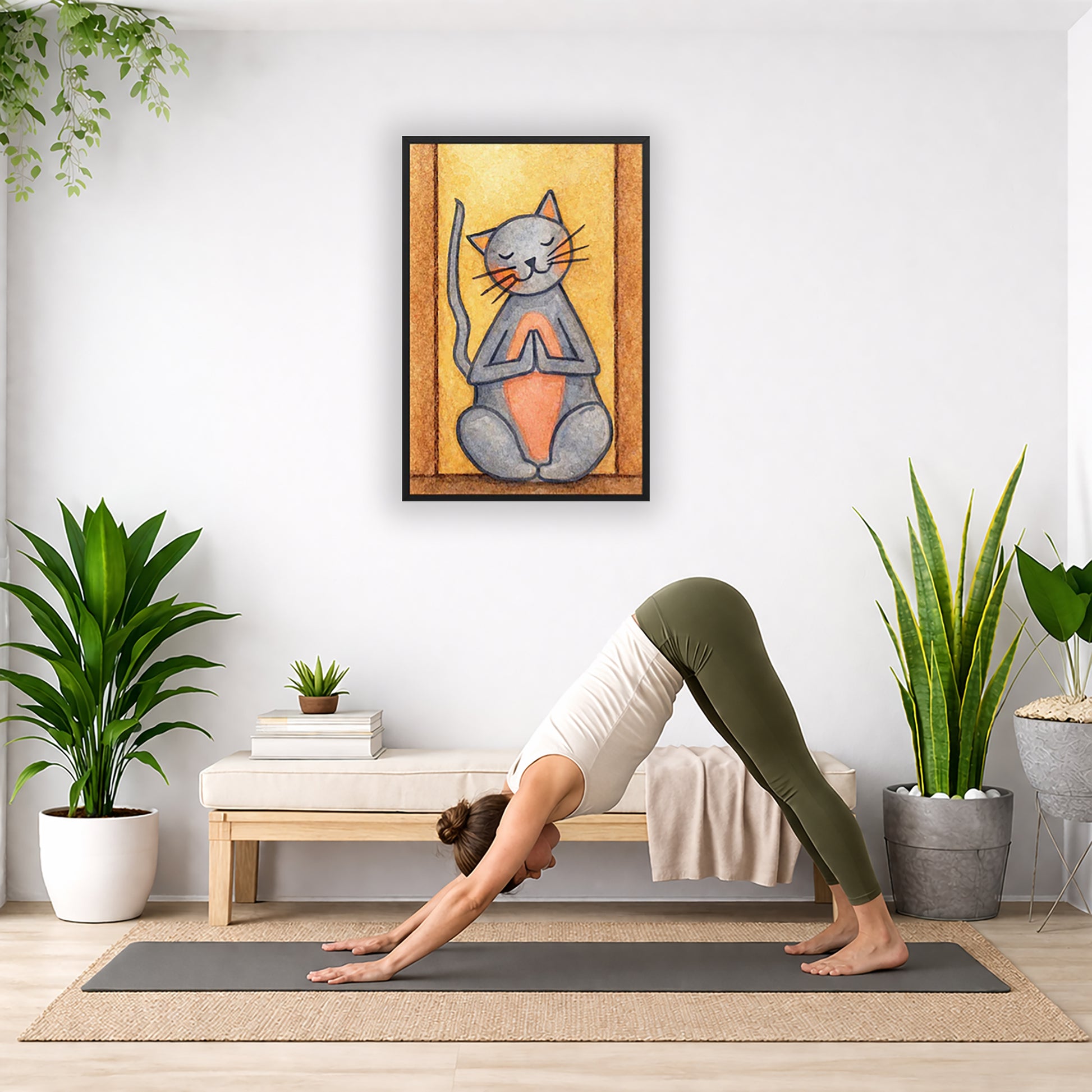 A gray cat with a pink belly is doing a standing meditation framed poster.  This is a print of the original hand-painted watercolor by Brazilian artist Thaís Suizo.   The poster is in the center of the living room wall. Below the poster a woman is doing the yoga posture downward facing dog on a yoga mat.

