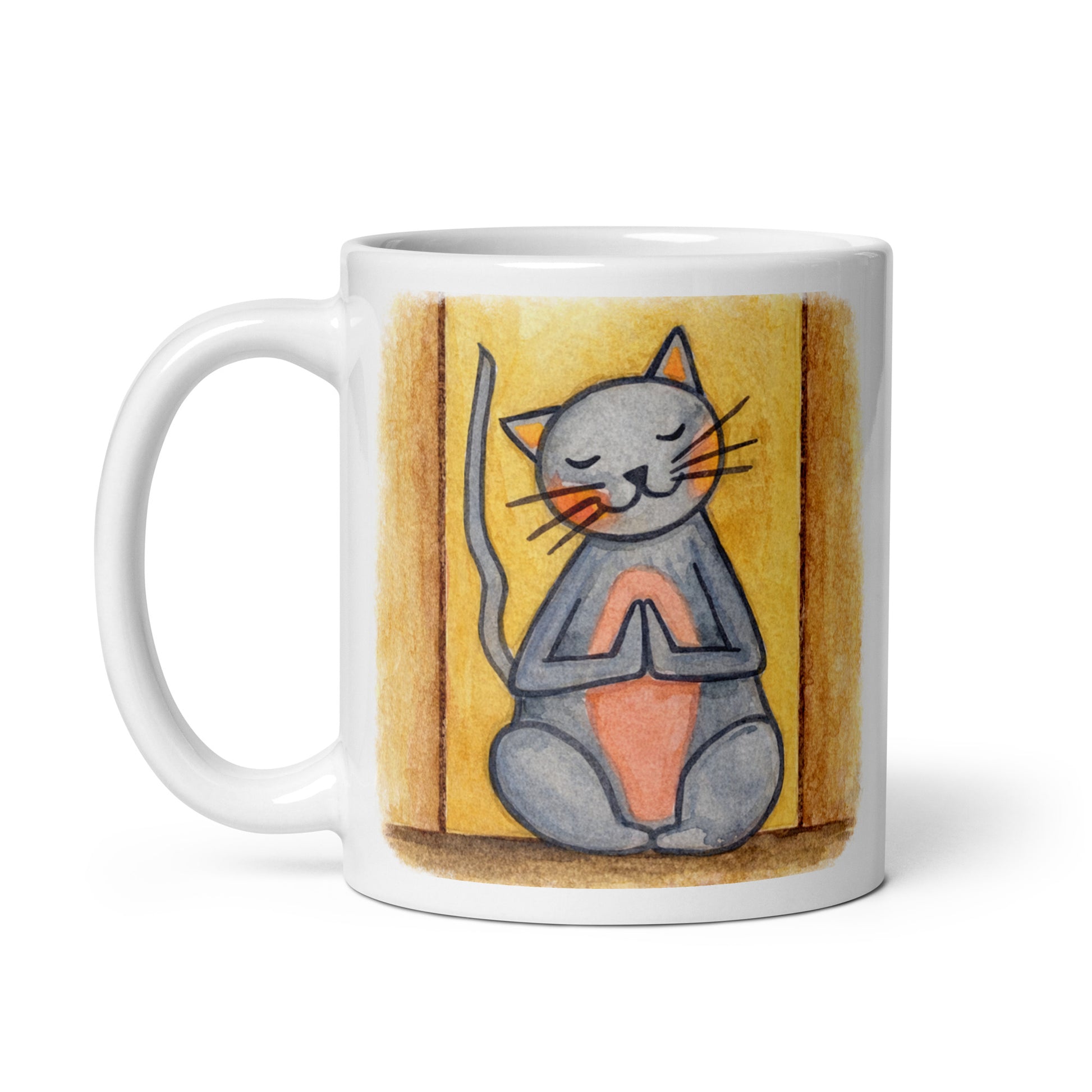 Gray cat with a pink belly on a yellow background is sitting in a peaceful meditation pose with praying paws in front of its chest. This illustration of a cat meditating is on both sides of the mug. In this image the handle of the mug is on the left side.