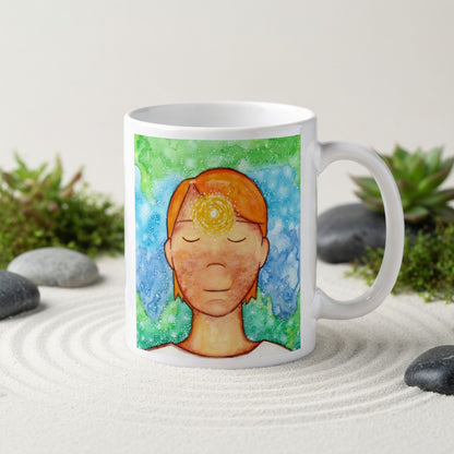 Man meditating with glowing third eye chakra on forehead, symbolizing intuition, awareness and inner vision, spiritual chakra artwork on a meditation themed coffee mug.  The mug is in a beautifully raked zen garden with bushes and plants behind it.