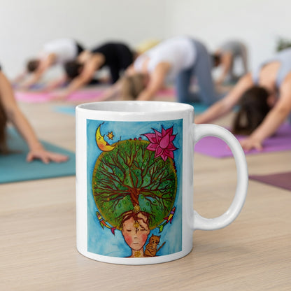 Poster of the crown chakra of a woman opening up like the tree of life.  The mug is in front of a yoga class doing the downward facing dog posture.