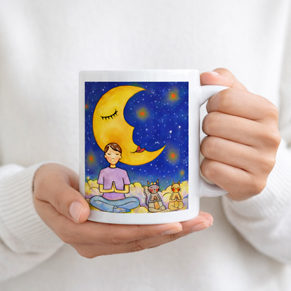 Man and his cats are meditating atop a cloud under the moon in a mindfulness poster.  The hands of a person wearing a white sweater are holding the mug up to display the design.