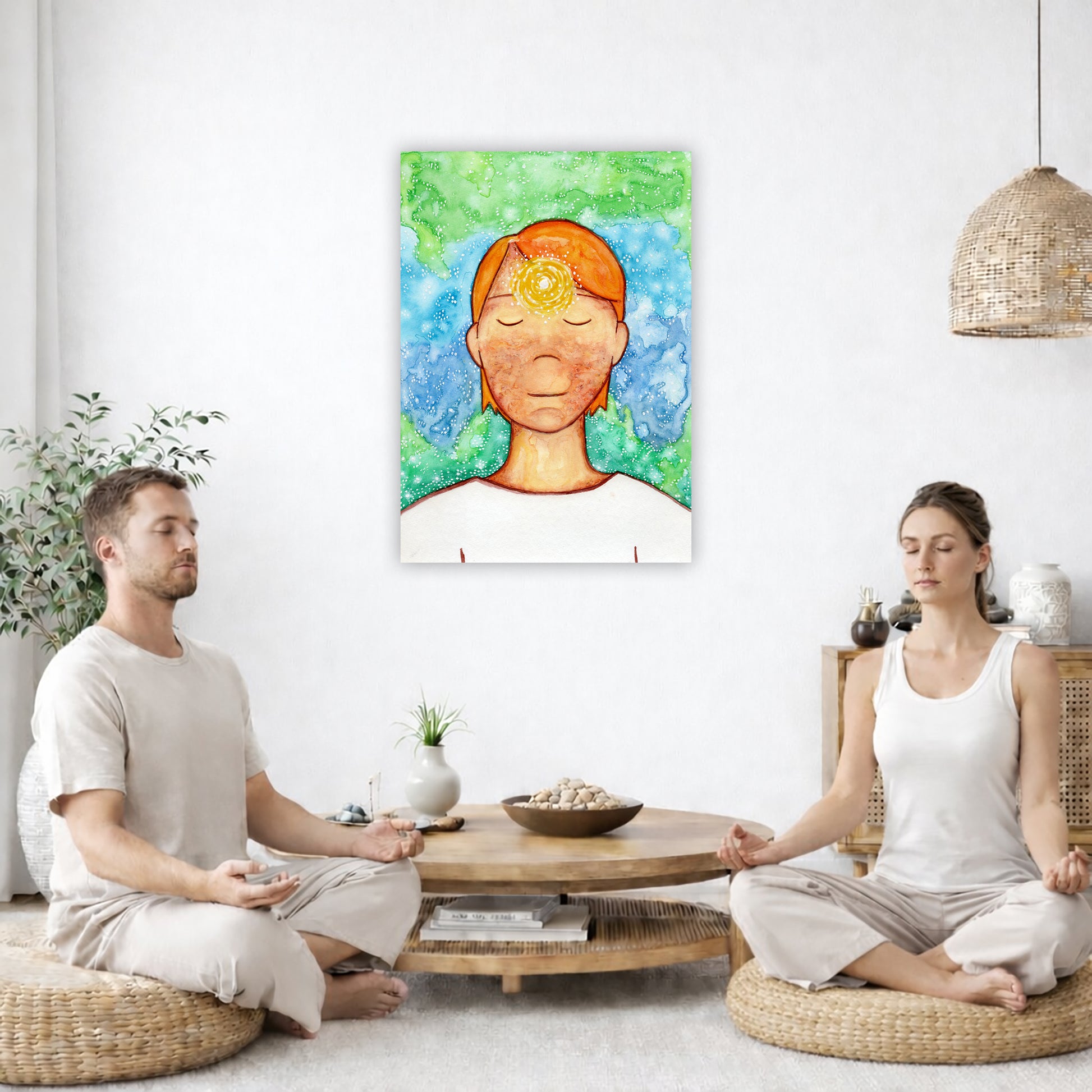 Man meditating with his brow chakra glowing canvas print.  The poster is in the center of the living room wall. Two friends are sitting on wicker pillows meditating. Between them is a small round coffee table with incense, a green potted plant and a bowl of shells. There is a potted plant to the left and a Buddha statue and a vase to the right. 
