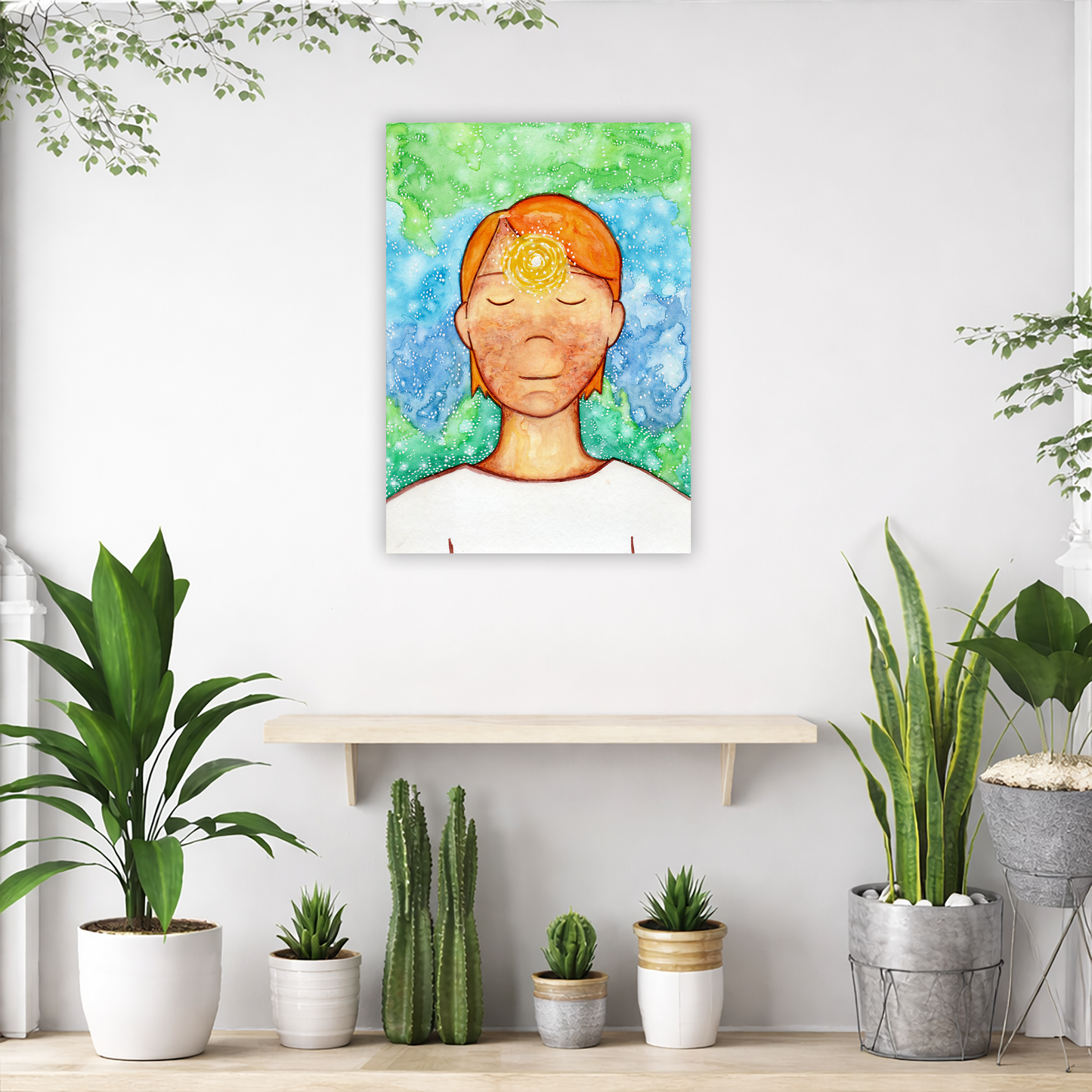 Man meditating with his brow chakra glowing canvas print.  The poster is in the center of the living room wall. Below the poster is an empty shelf. Below the shelf is a variety of green potted plants including a few cactus.
